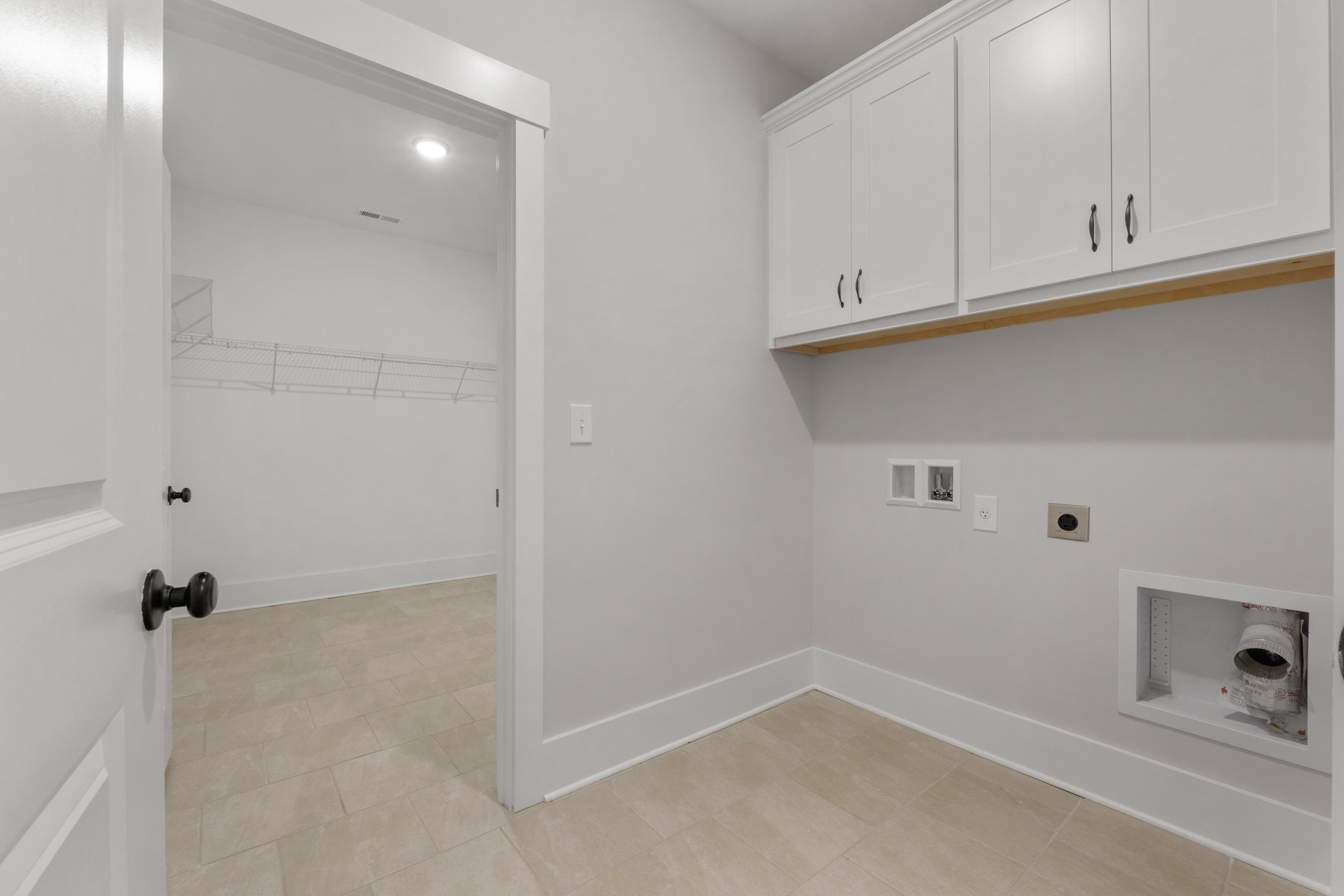 Spacious laundry room at The Villas at Barnett's Crossing in Madison Alabama with white cabinets and washer dryer hookups