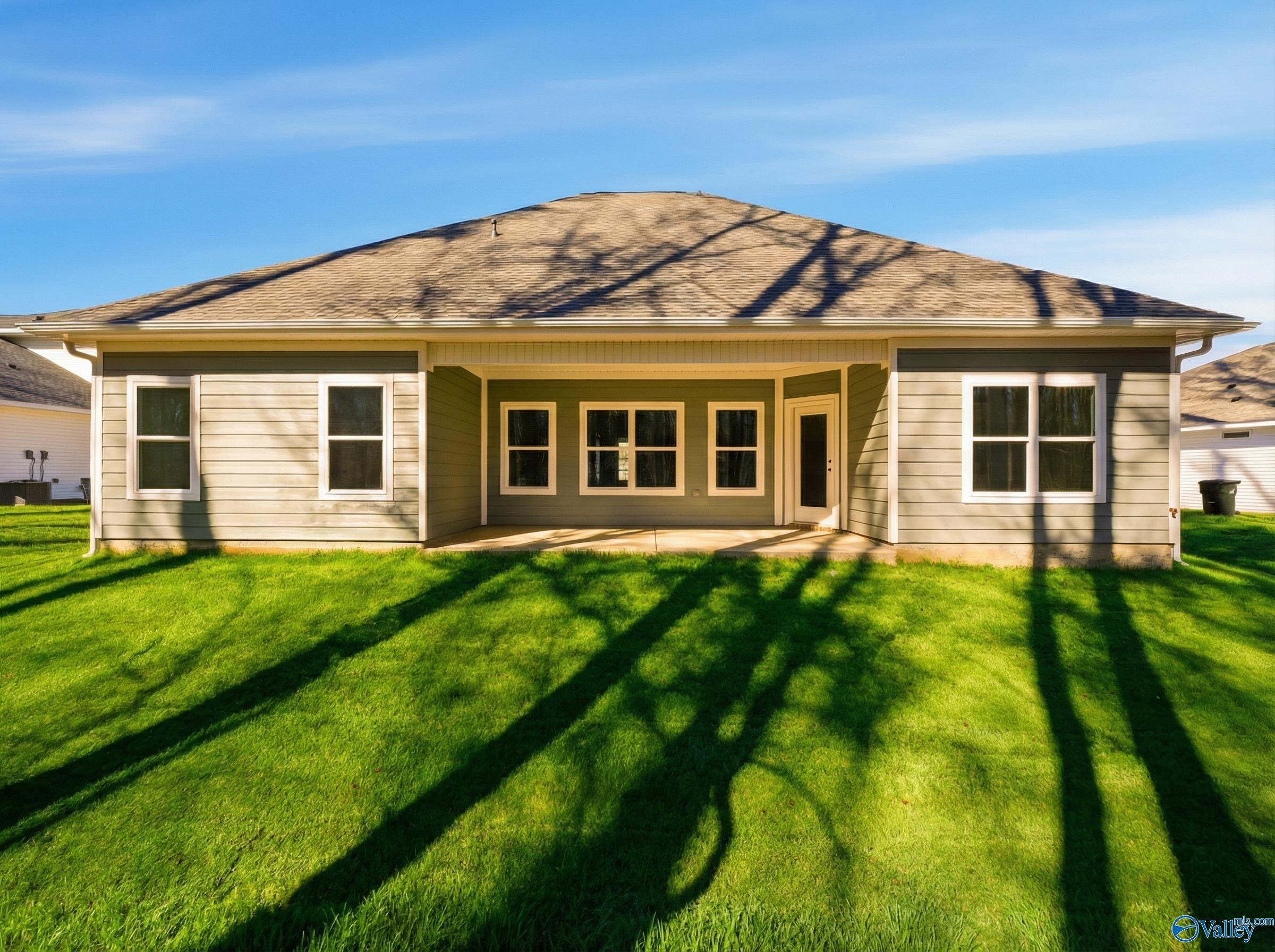 The Rockford D single-story home by Davidson Homes, beige exterior with covered porch, windows, garage and lush green lawn in Forest Glen, Hazel Green, Alabama