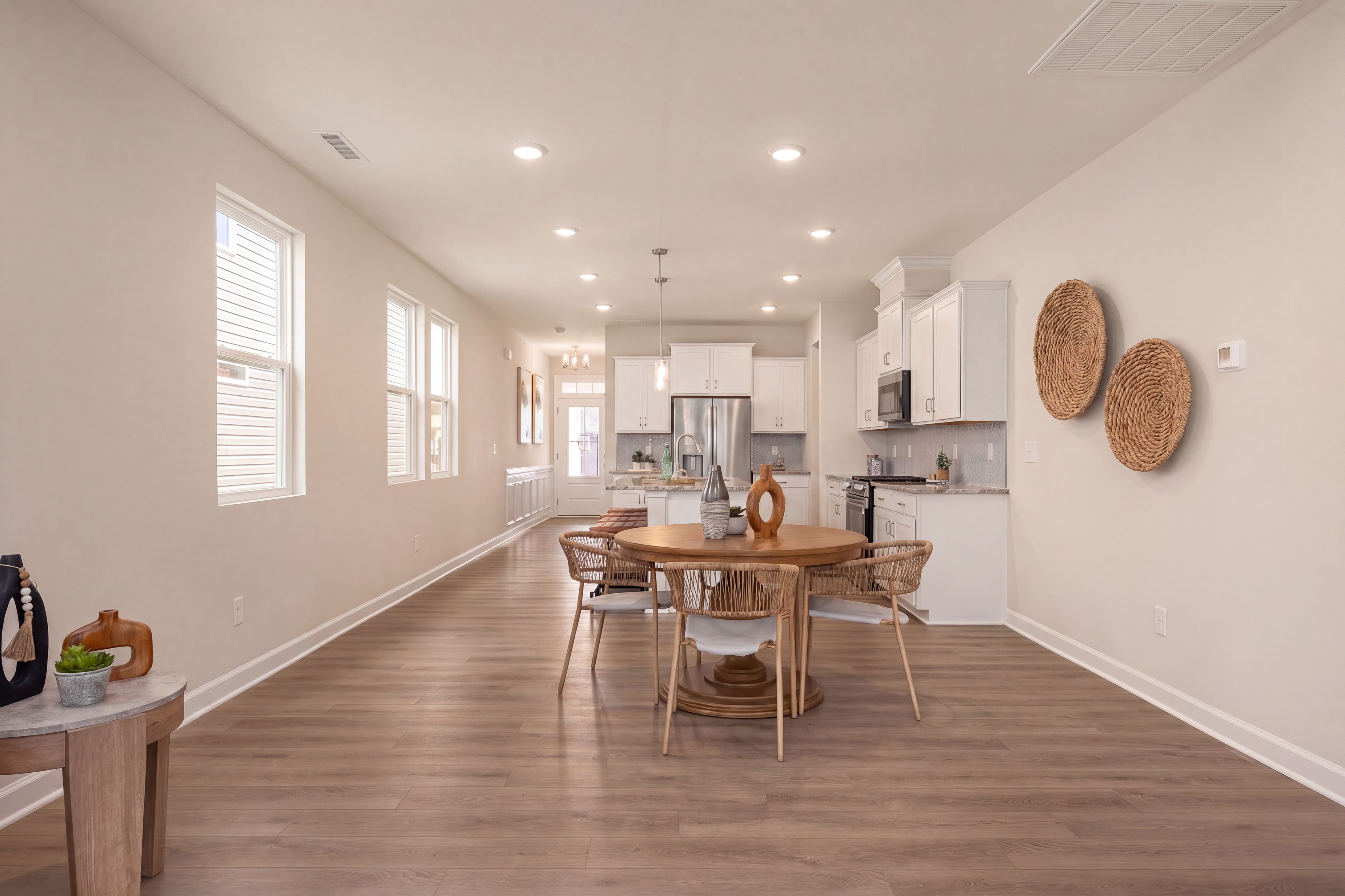 Open-concept kitchen and dining area at Gregory Village in Lillington, NC by Davidson Homes with modern white cabinetry.