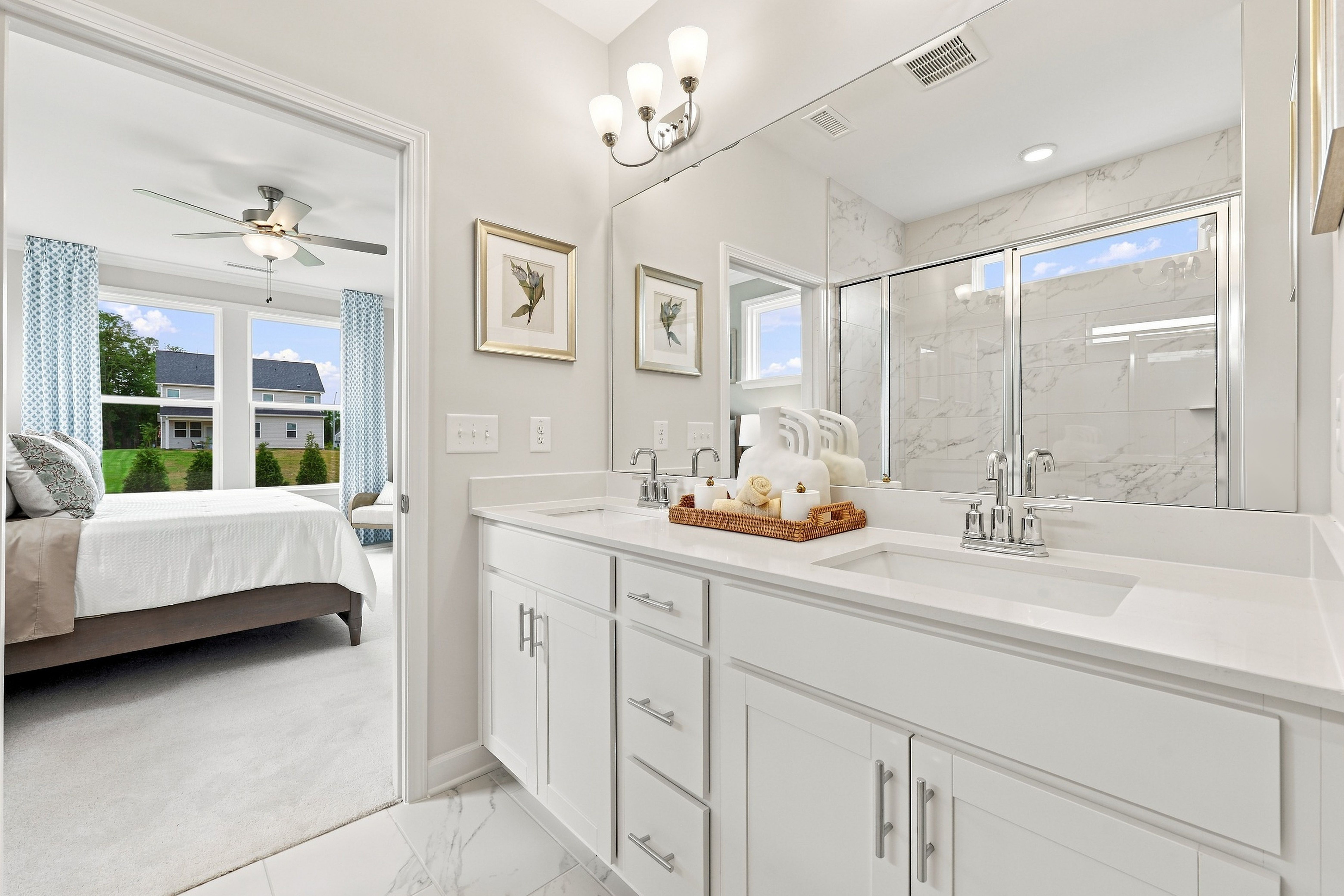 Spacious master bathroom in The Daphne featuring dual vanity, marble-style tile, and direct access to the main floor bedroom.