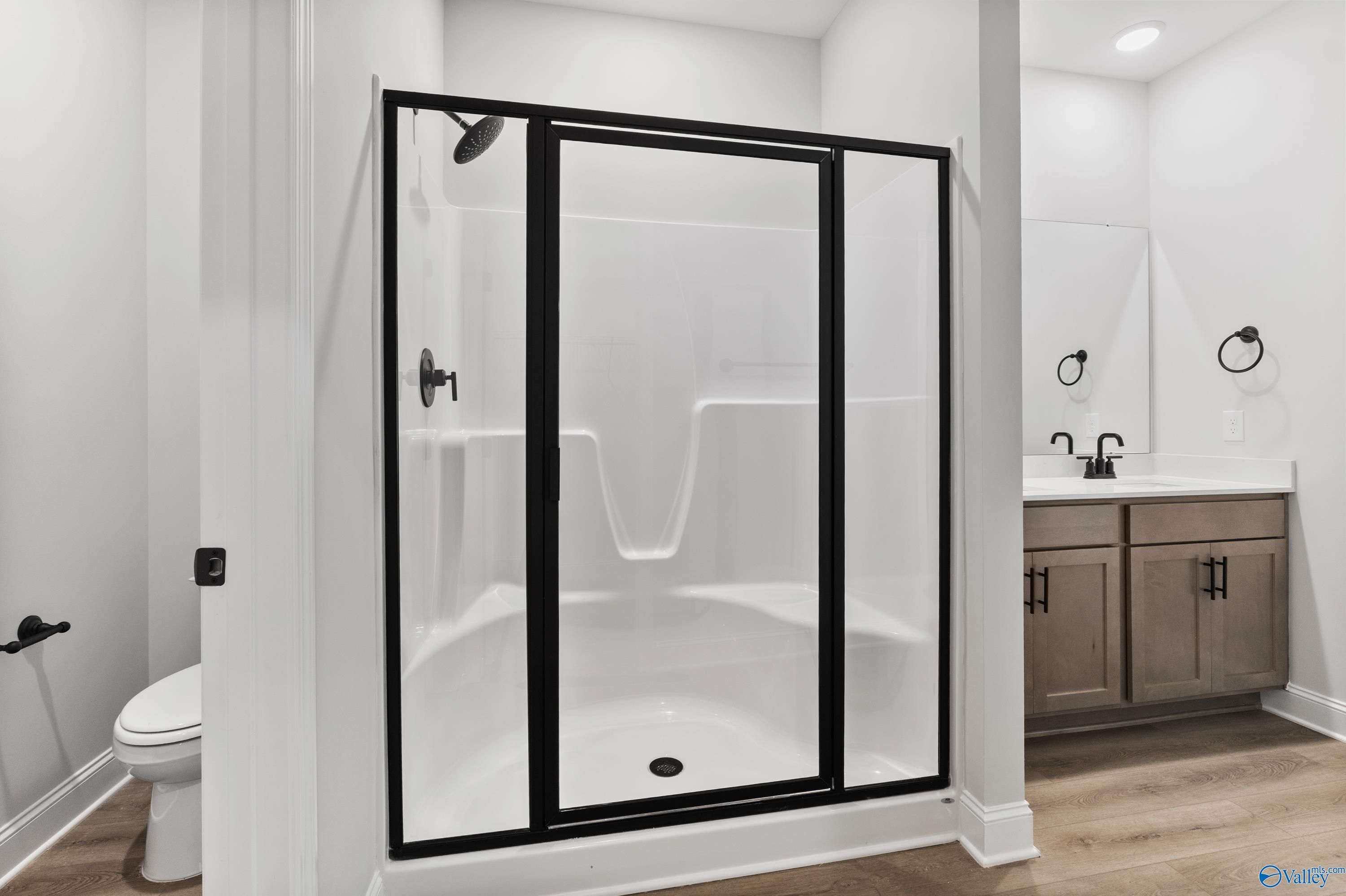 Modern master bathroom with frameless glass walk-in shower and double shaker vanity in Davidson Homes The Daphne, Huntsville AL