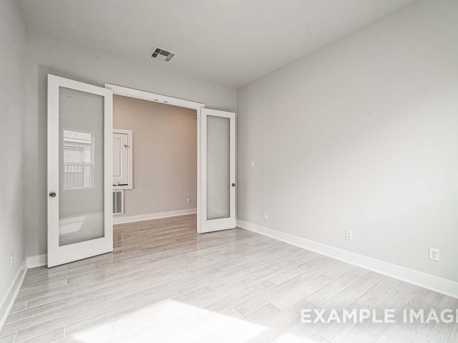 Bright home office or flex room with French doors and light wood-look tile in The George A floor plan, Sierra Vista.