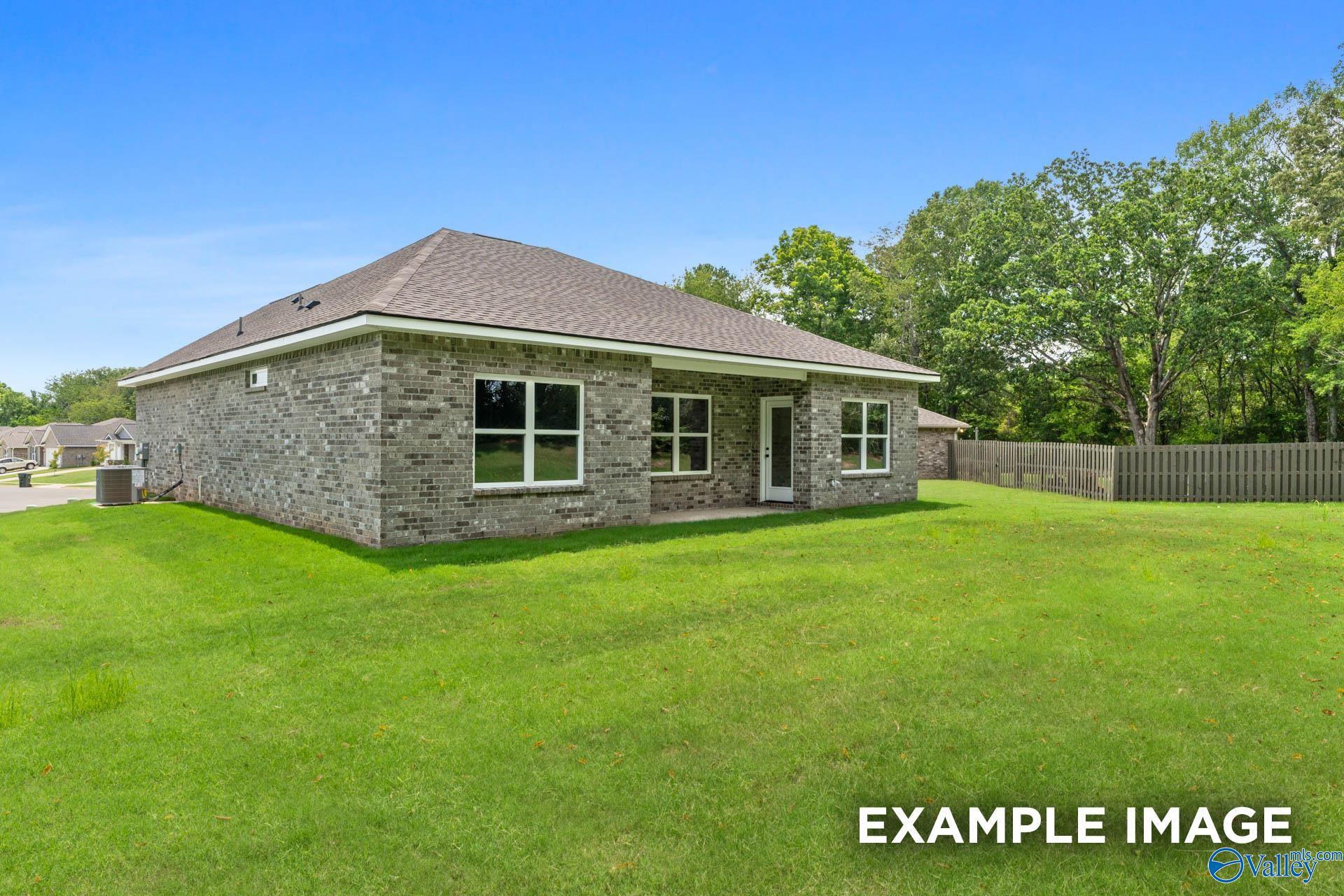 Brick ranch-style home with gray shingle roof and large windows on lush green lawn in Clearview, Hazel Green, Alabama