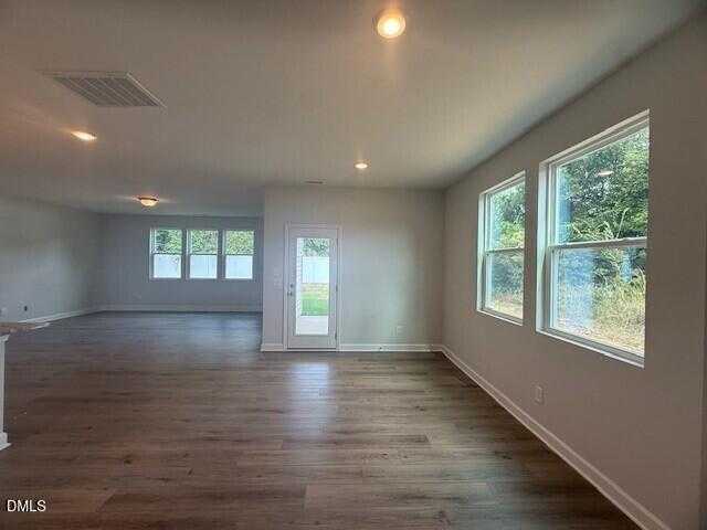 Bright open living area with hardwood floors, large windows, and French doors in Davidson Homes The Preston C, Lillington, NC
