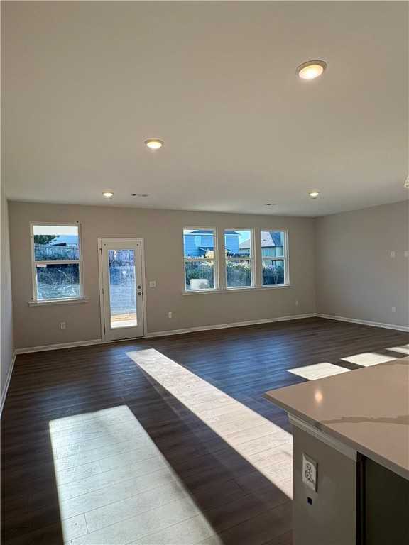 Bright open-concept living room with hardwood floors, large windows, sliding glass door, and quartz kitchen counter in Davidson Homes Luna B, Opelika AL