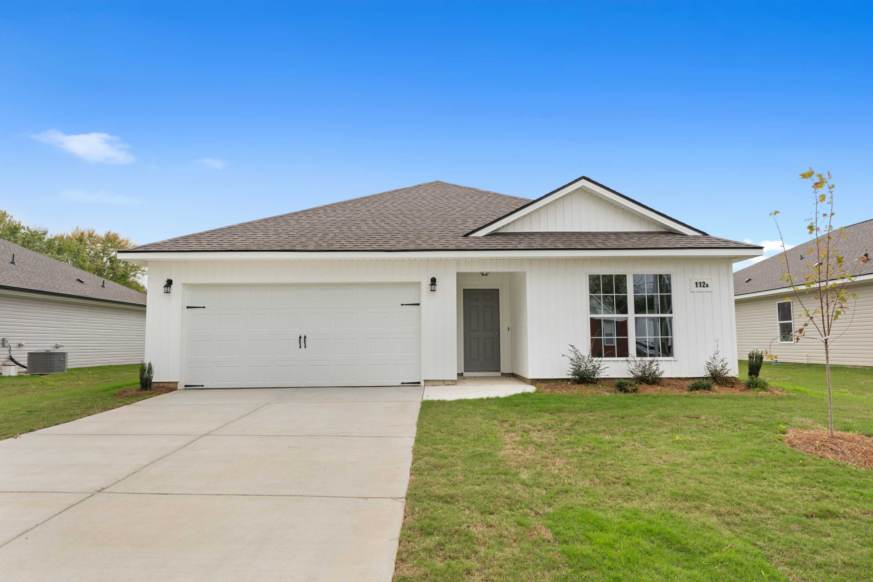 Modern white farmhouse-style home exterior at Chapel Hill in Athens, Alabama with gabled roof, two-car garage, and landscaped yard