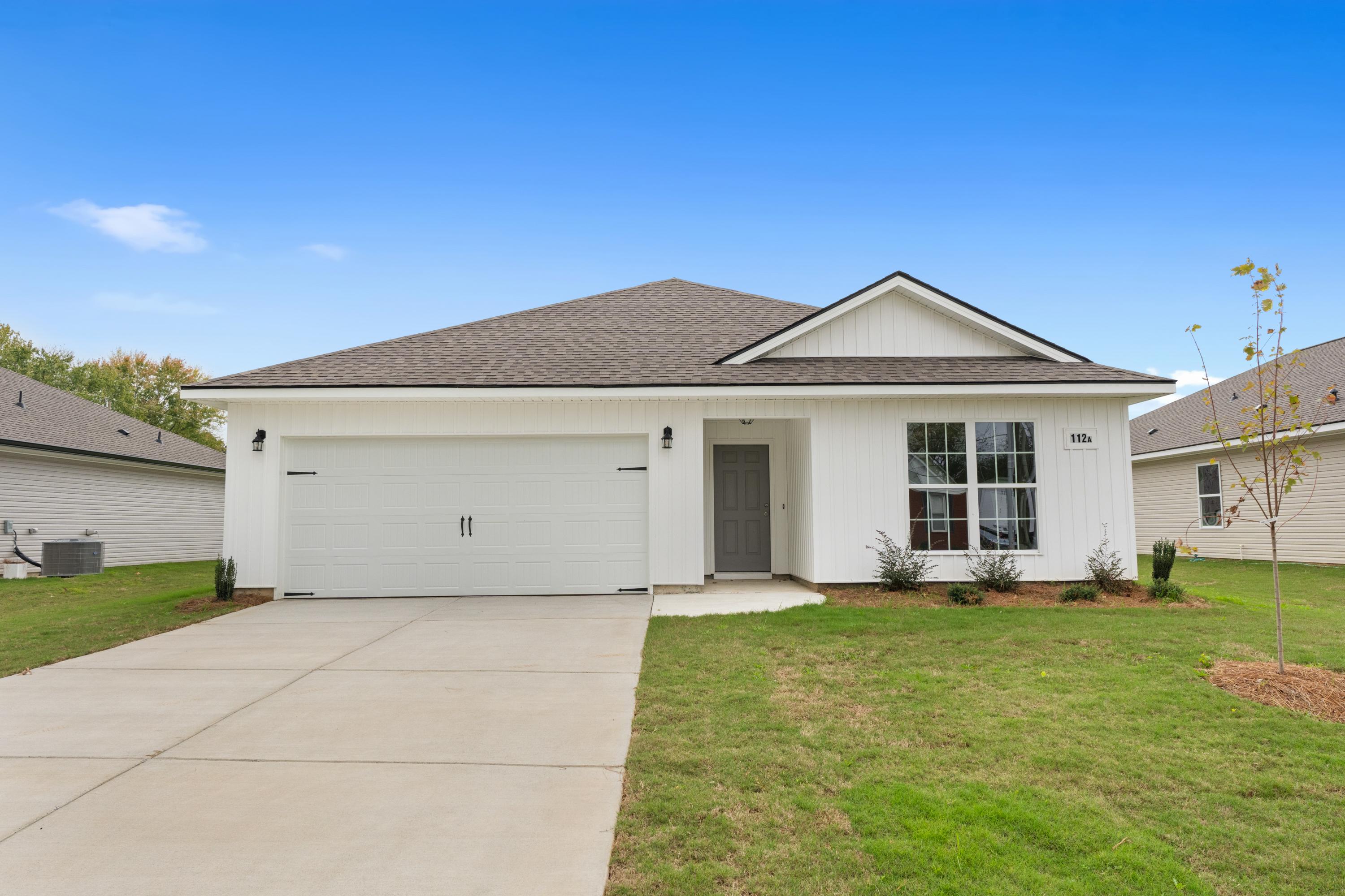 Modern white farmhouse-style home exterior at Chapel Hill in Athens, Alabama with gabled roof, two-car garage, and landscaped yard