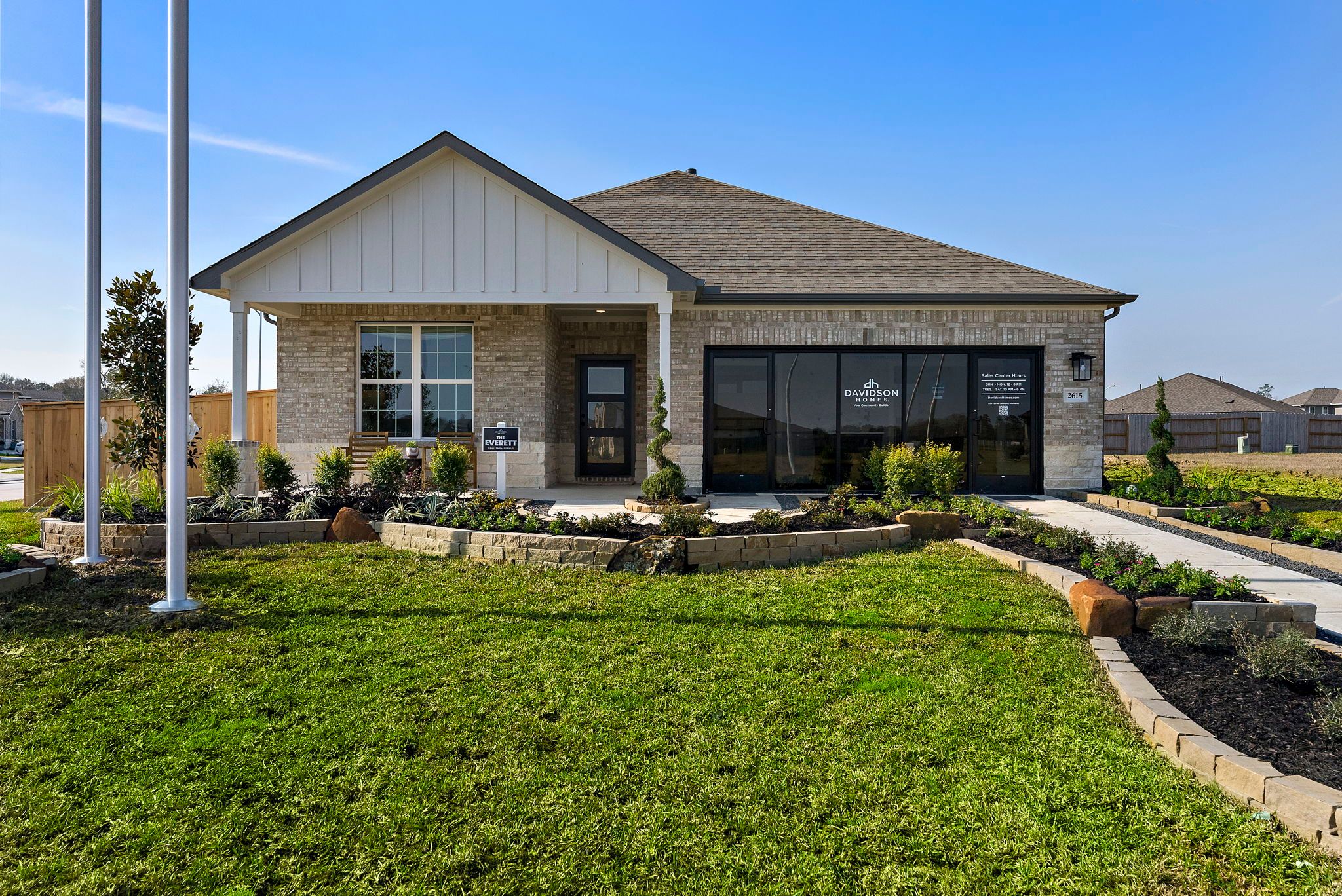 Open-concept kitchen and living room in Sundance Cove Crosby Texas with white island, hardwood floors, ceiling fan and modern white seating