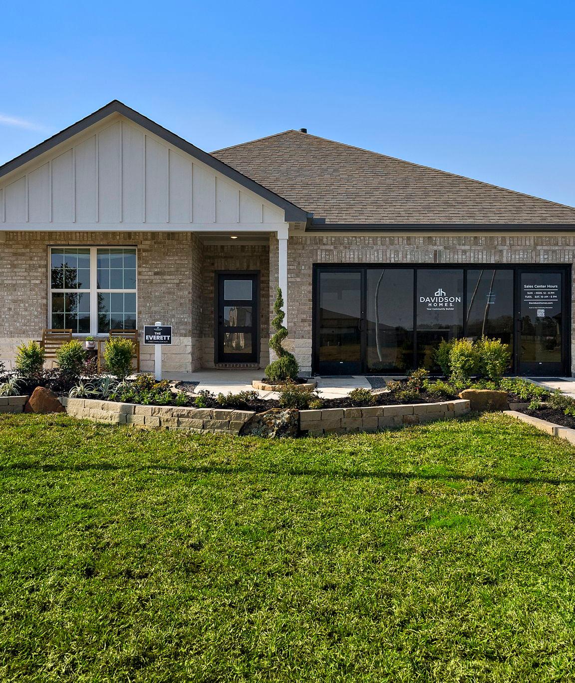 Open-concept kitchen and living room in Sundance Cove Crosby Texas with white island, hardwood floors, ceiling fan and modern white seating