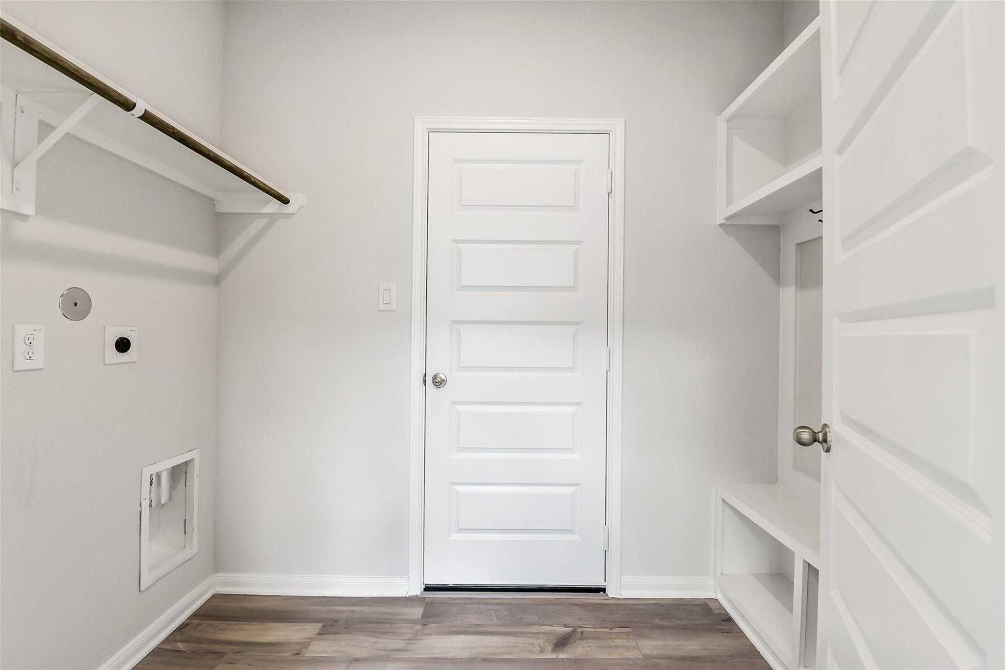Bright laundry room with built-in shelves, hanging rod, utility sink, washer/dryer hookups, and mudroom lockers in The Sabine E, Conroe, Texas