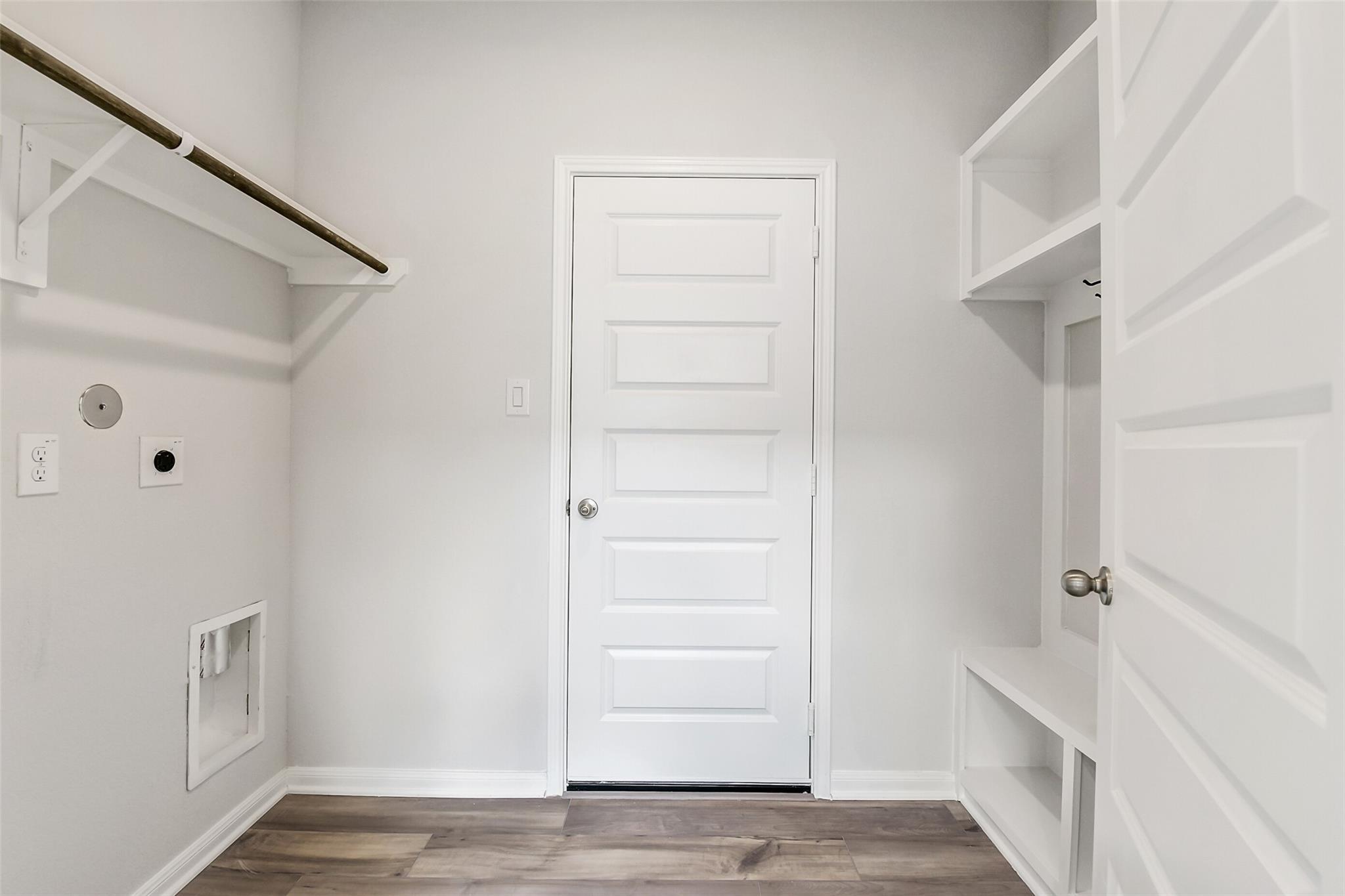 Bright laundry room with built-in shelves, hanging rod, utility sink, washer/dryer hookups, and mudroom lockers in The Sabine E, Conroe, Texas