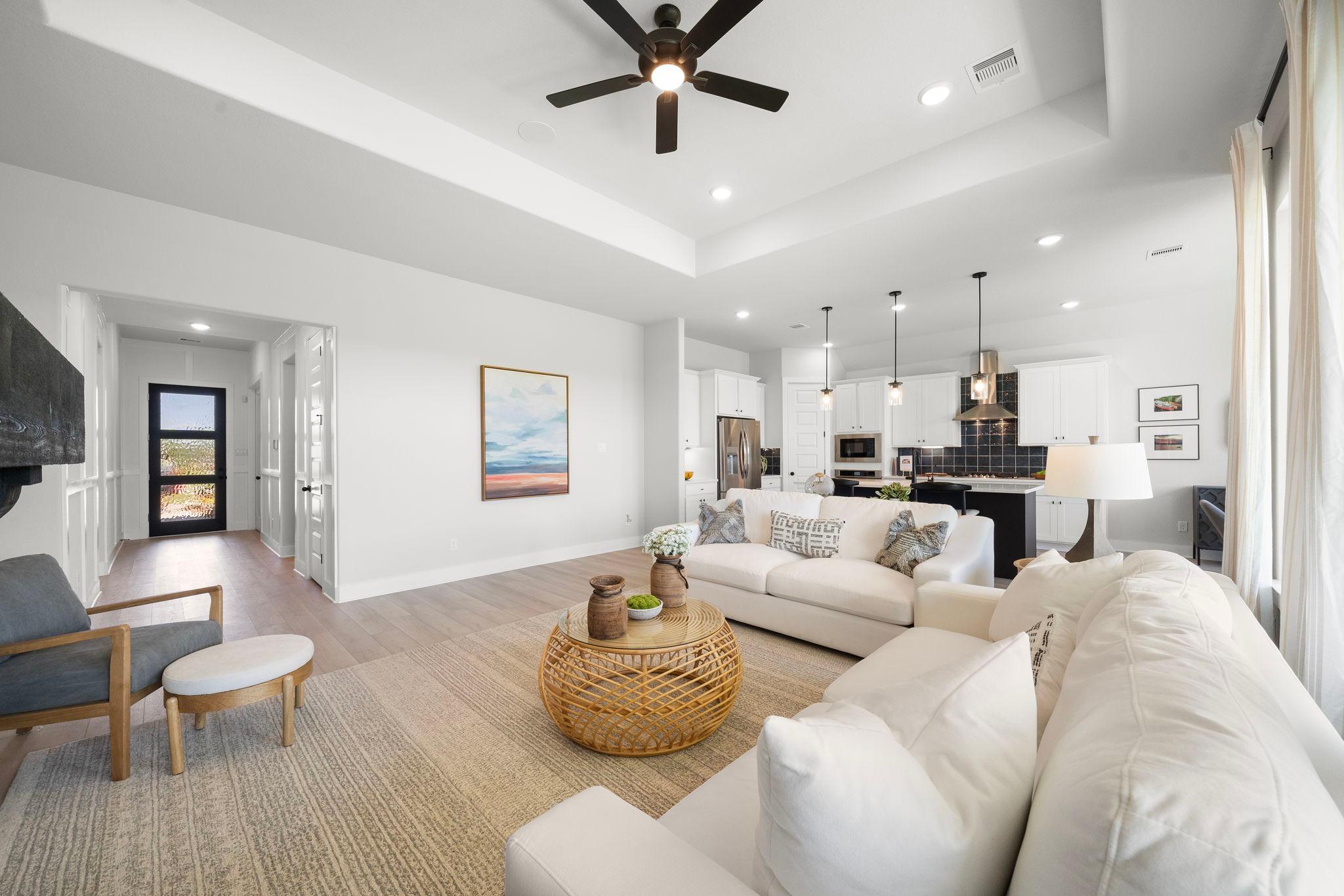 Open-concept living room at Lago Mar in Texas City, Texas with plush white sofa, rattan coffee table, and adjacent white kitchen
