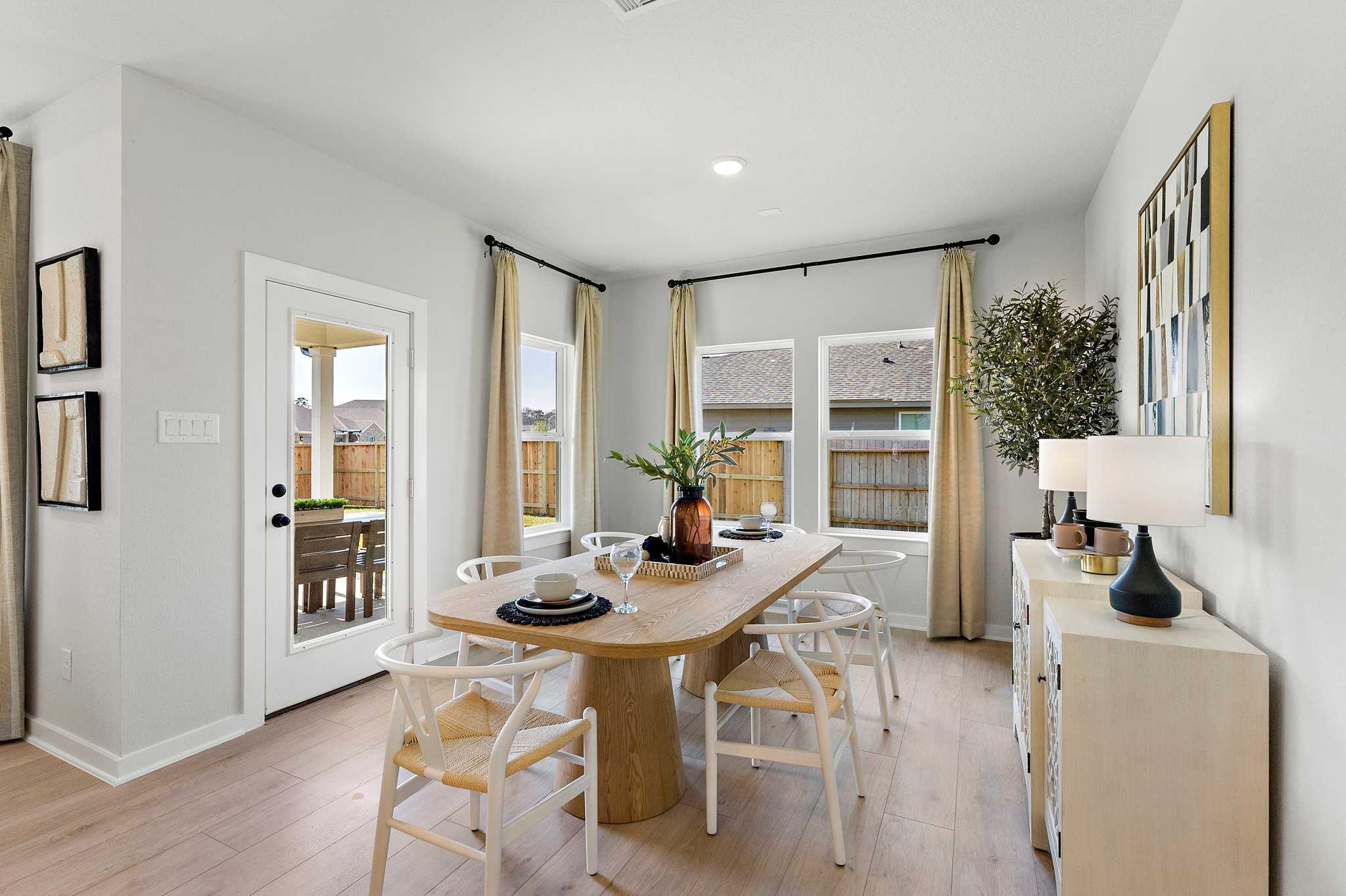 Modern dining room at Sundance Cove in Crosby Texas with oak table white chairs hardwood floors and large windows
