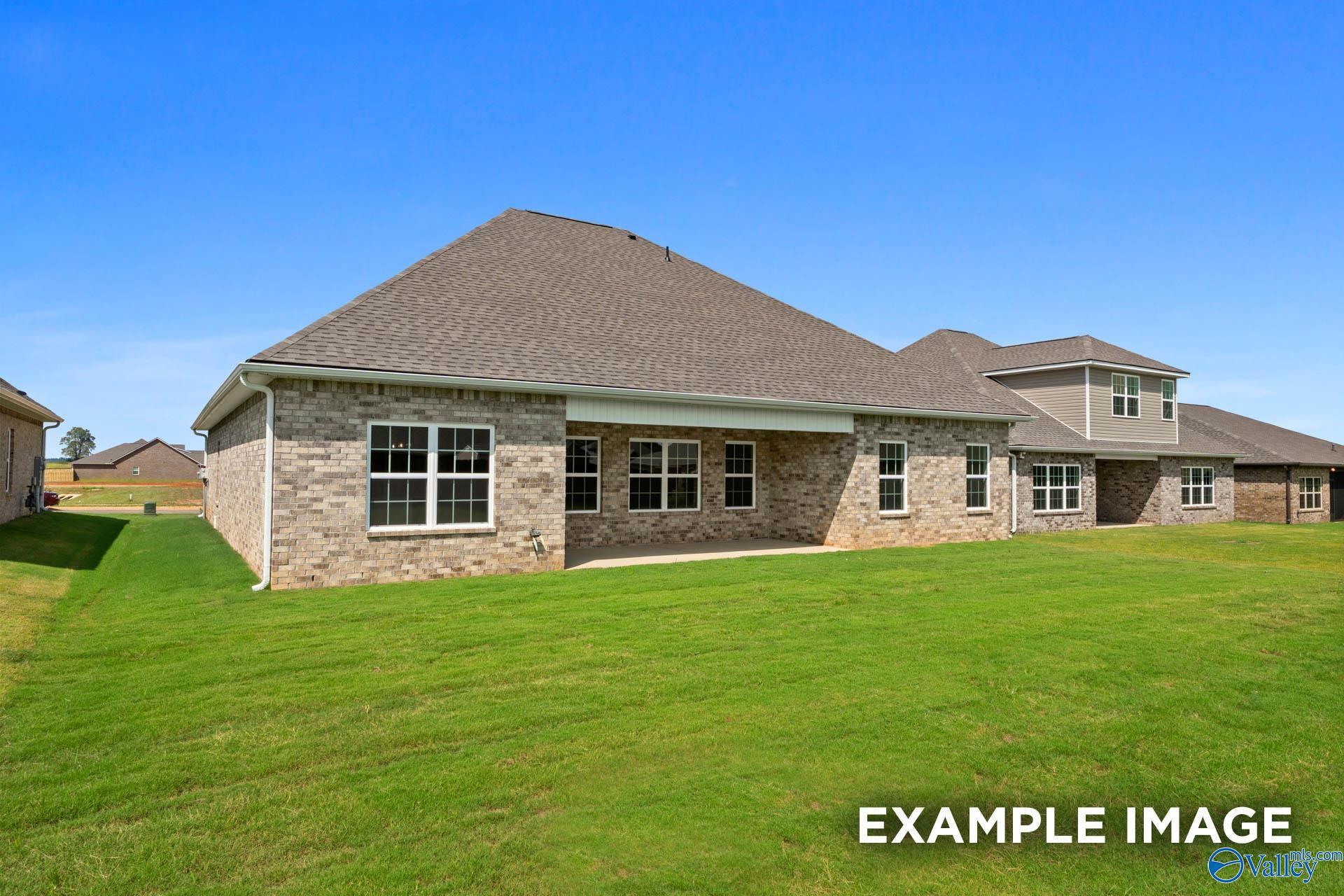 Rear exterior view of The Rockford B home by Davidson Homes with brick facade and spacious backyard in Kendall Downs, Toney.