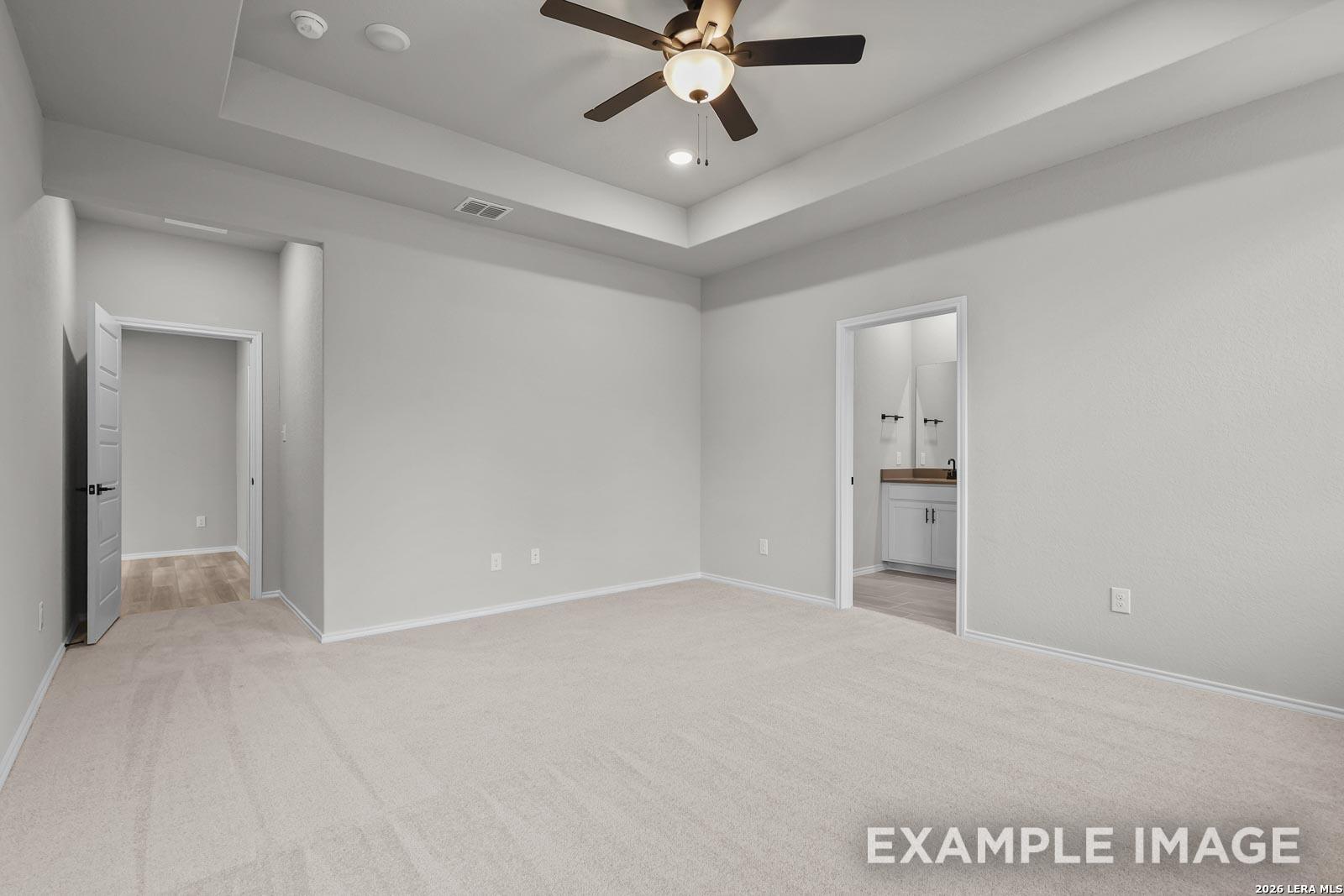 Spacious primary bedroom with tray ceiling and en-suite bathroom in Davidson Homes The Glenwood E, Royal Crest, San Antonio.