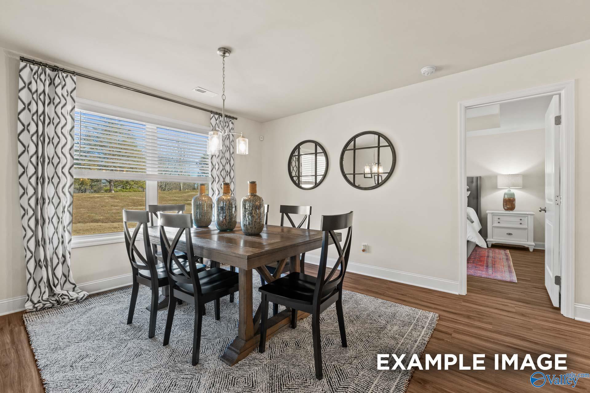 Bright dining room with farmhouse table, black X-back chairs, and wood-look flooring in Davidson Homes Franklin C plan, Owens Cross Roads