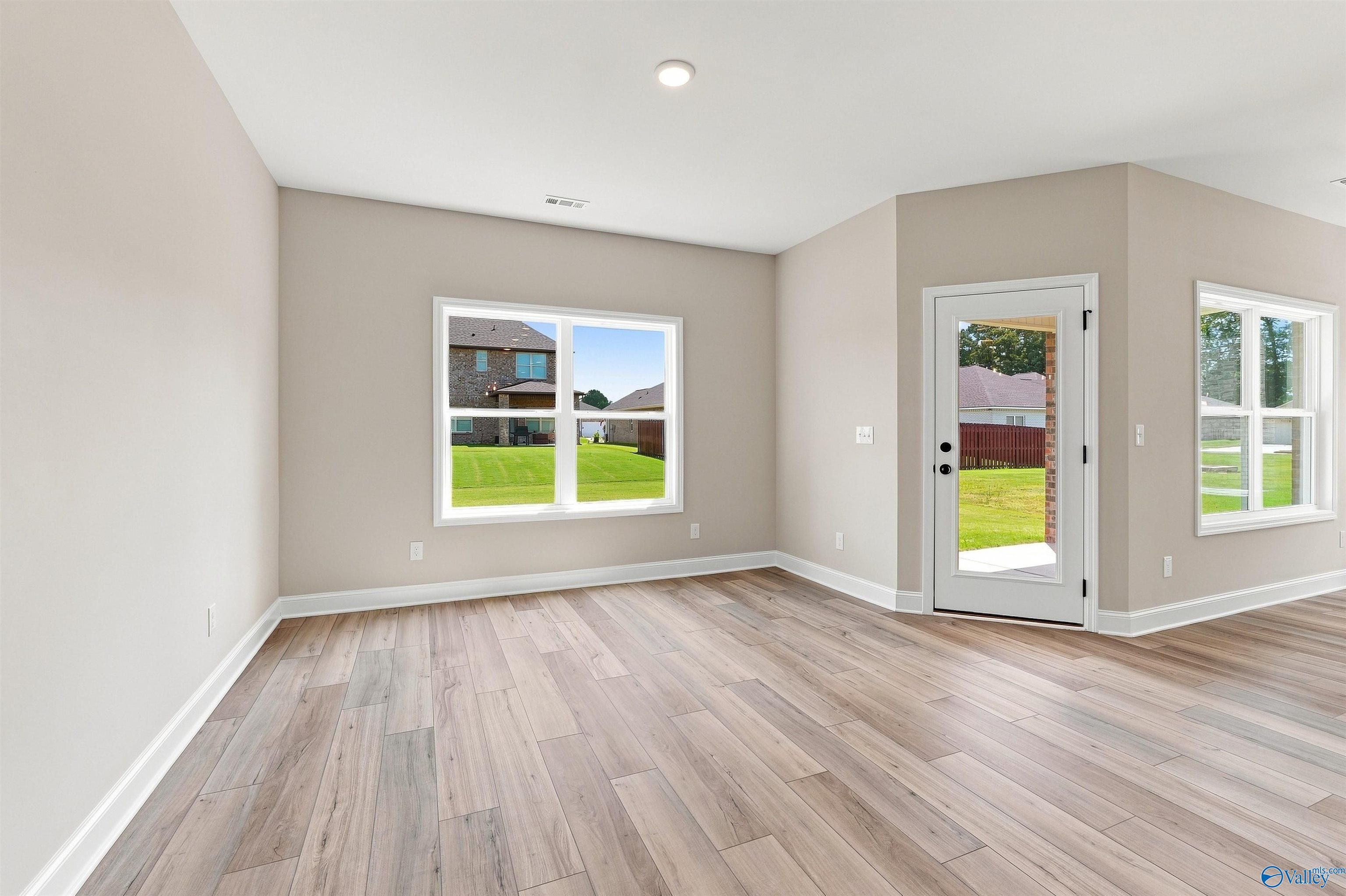 Bright open-concept living room with luxury vinyl plank flooring in Davidson Homes The Franklin C, Wood Trail, Toney, Alabama