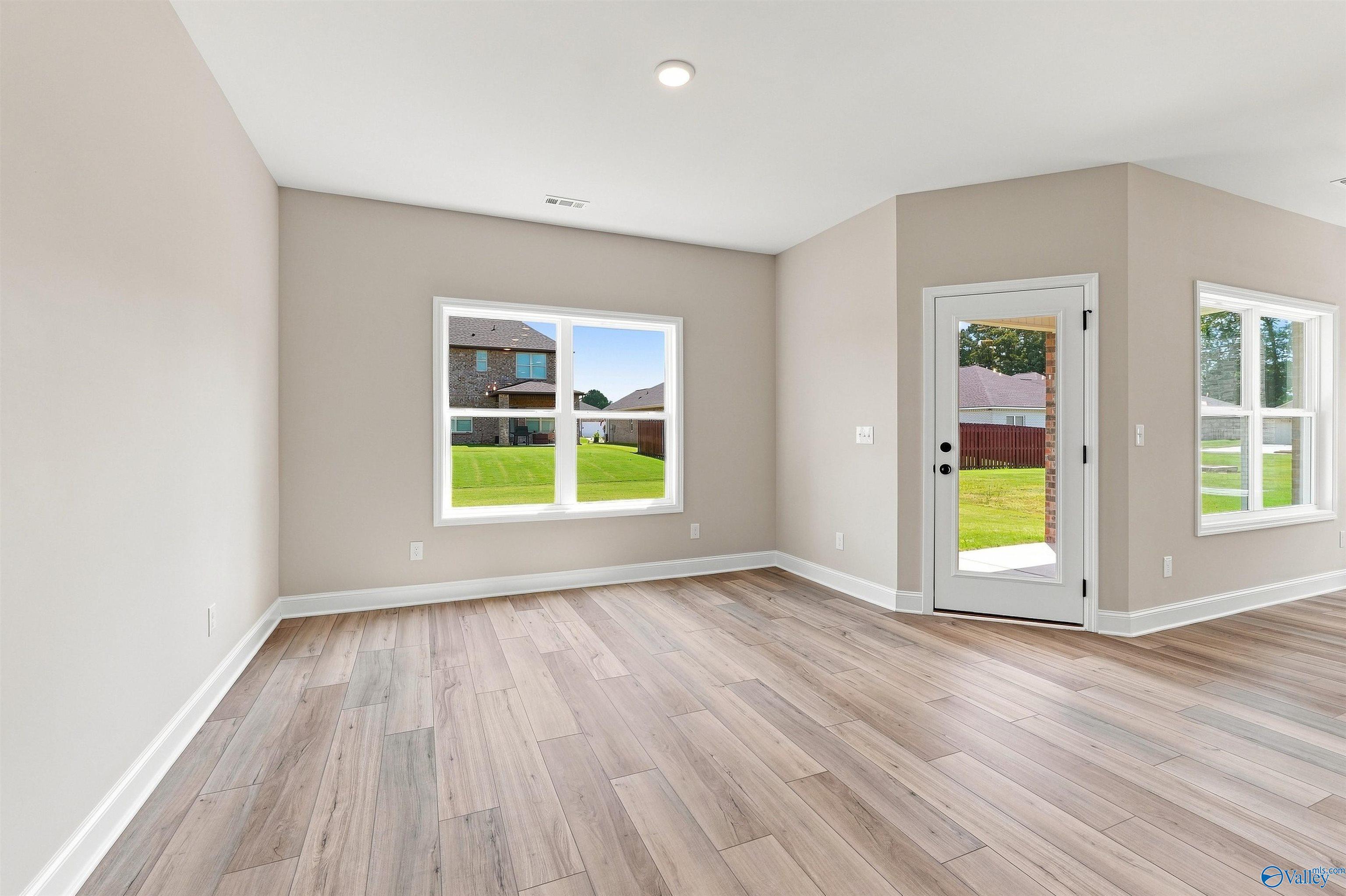 Bright open-concept living room with luxury vinyl plank flooring in Davidson Homes The Franklin C, Wood Trail, Toney, Alabama