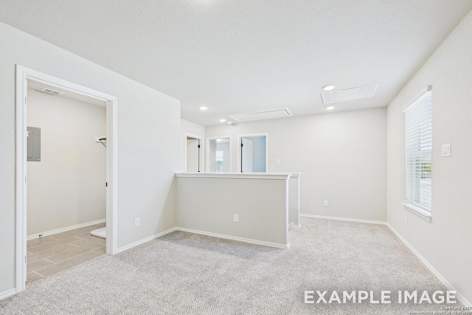 Bright upstairs loft with bar counter, laundry room, and carpeted flooring in Davidson Homes The Charlotte B, San Antonio