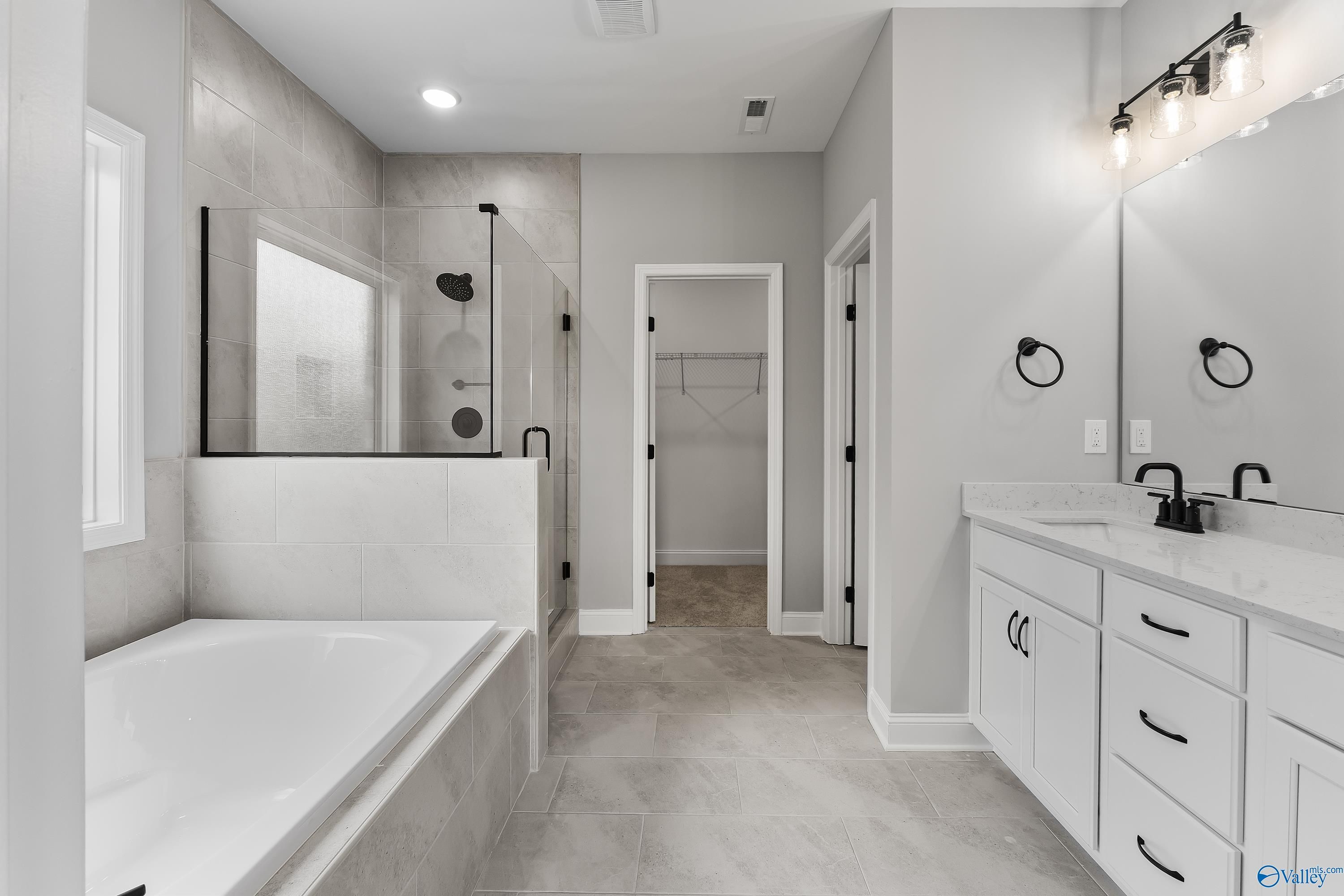 Modern master bathroom featuring walk-in glass shower, freestanding tub, and double vanity in Davidson Homes Montgomery B With Bonus, Toney, Alabama