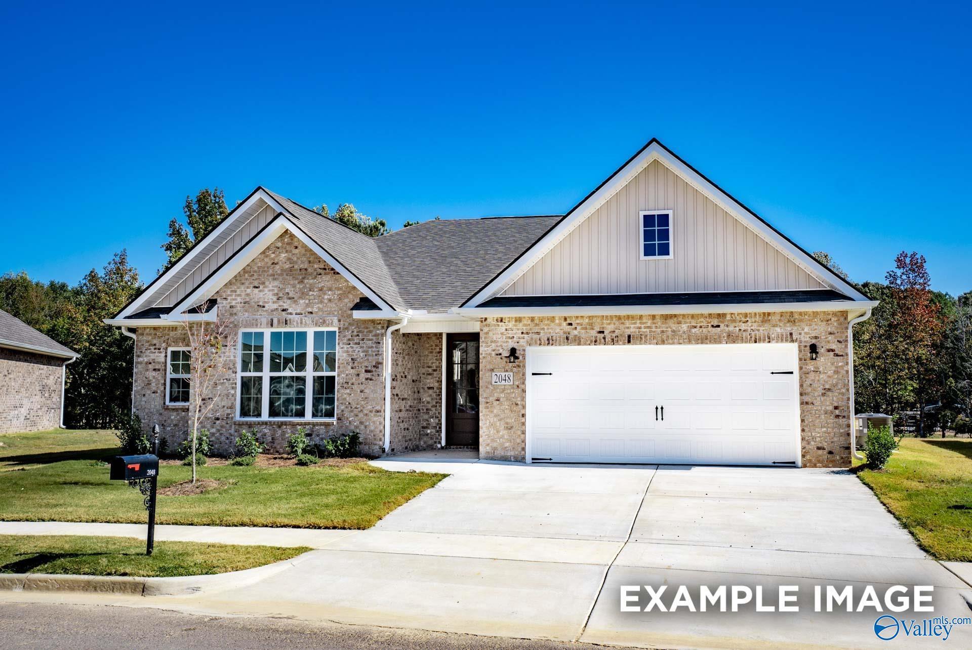 Modern brick ranch home with 2-car garage, gable roof, and lush lawn in Creekside, Harvest, Alabama by Davidson Homes