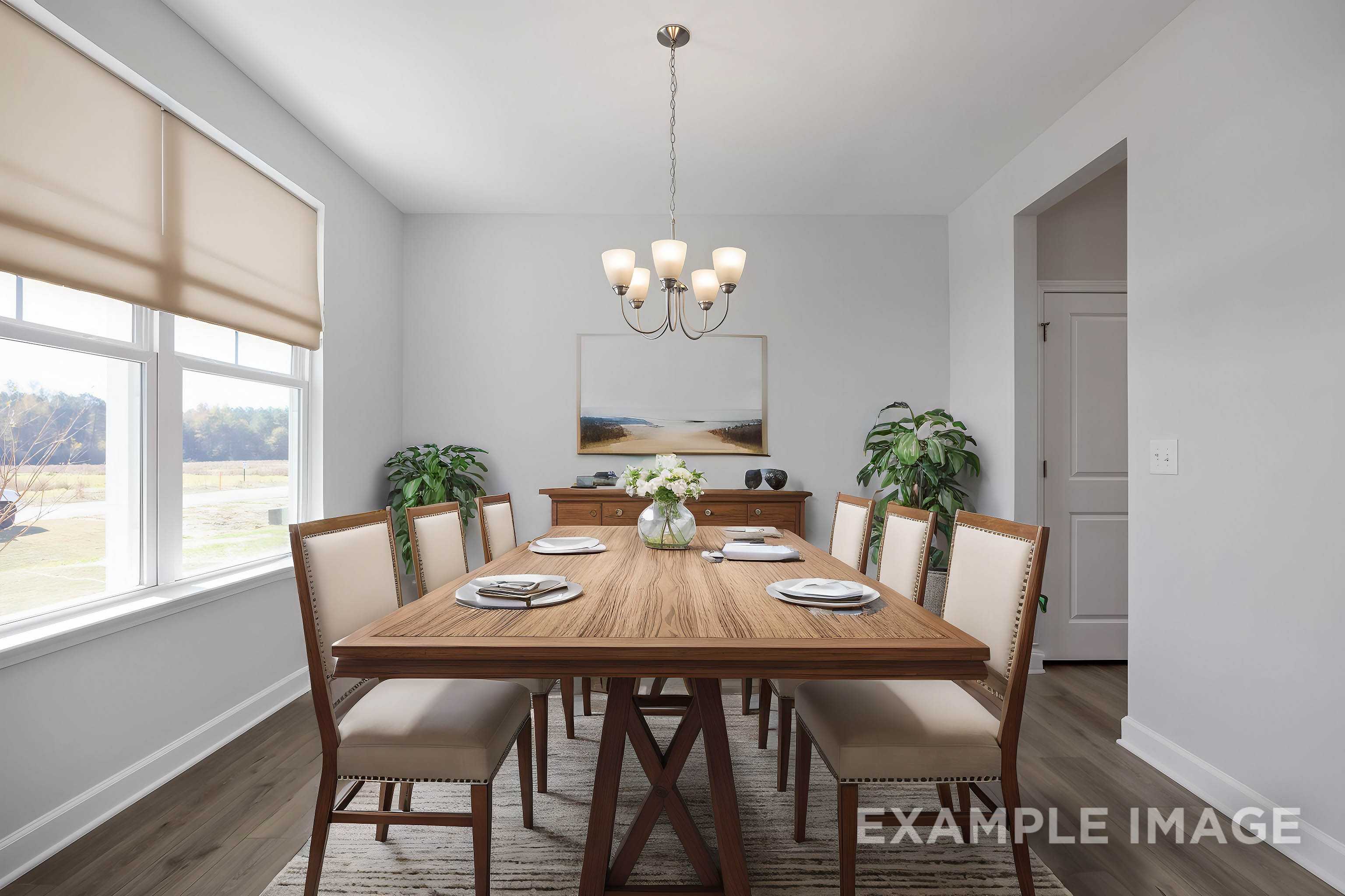 Spacious dining room in The Ash C featuring wooden trestle table, chandelier, upholstered chairs, plants, and scenic window views