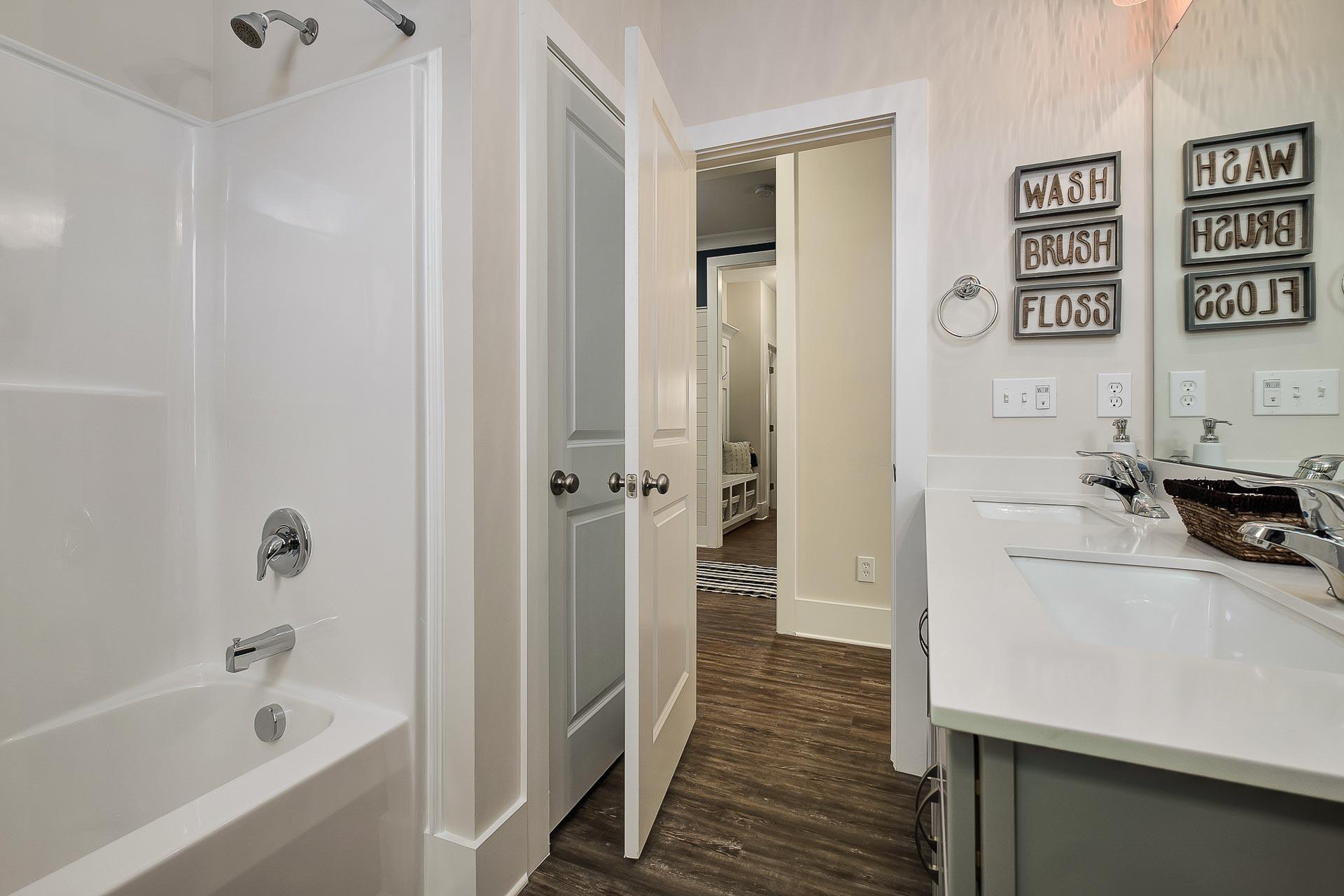 Spacious master bathroom in The Everett with walk-in shower, soaking tub, double vanity, and shiplap accents