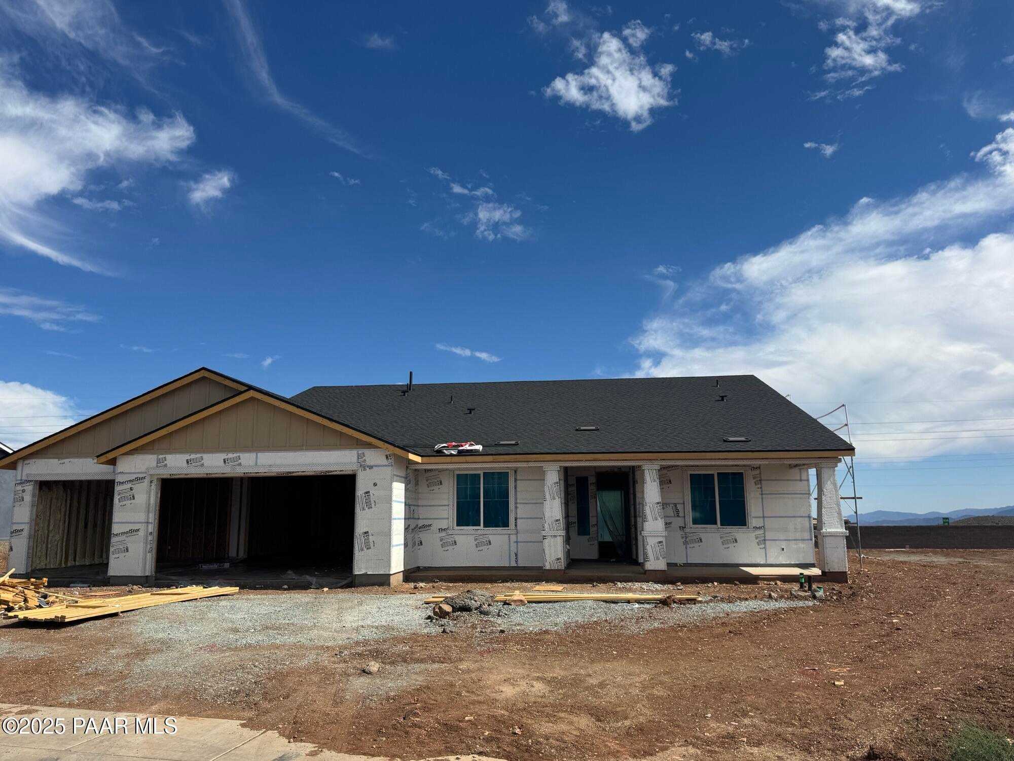 New construction 1-story home with 4-car garage, blue windows, and dark roof in Morningstar, Prescott Valley, Arizona by Evermore Homes