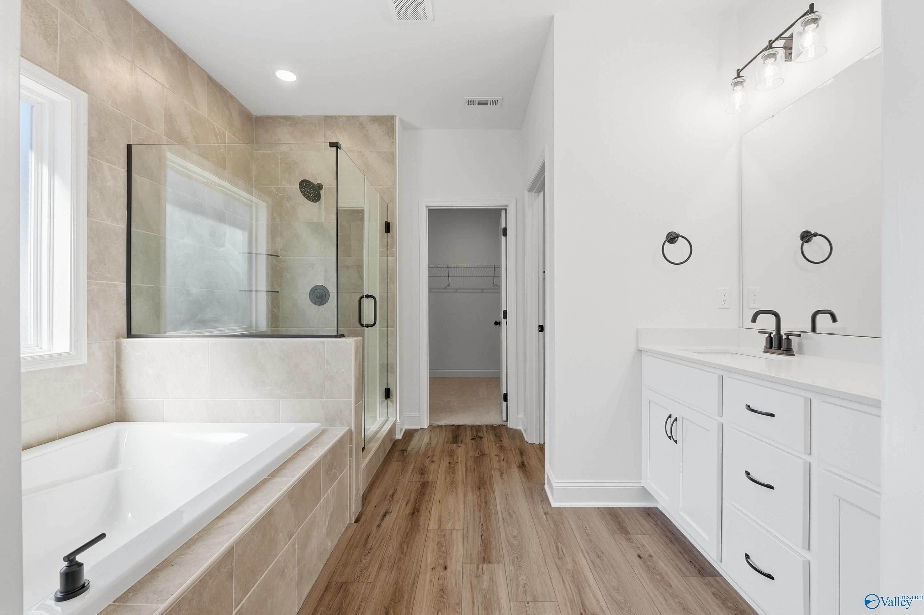 Elegant master bathroom featuring glass shower, freestanding tub, double vanity in Davidson Homes The Rockford D, Hazel Green, Alabama