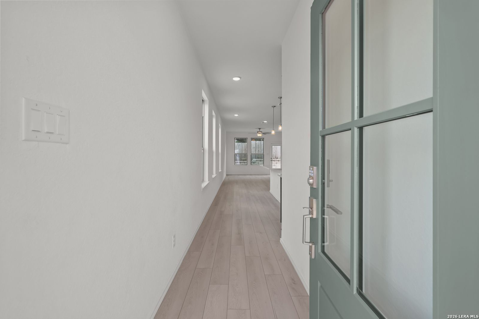 Bright entryway looking into open-concept living area of The Gillian C floor plan in Meadows at Oak Creek, San Antonio.