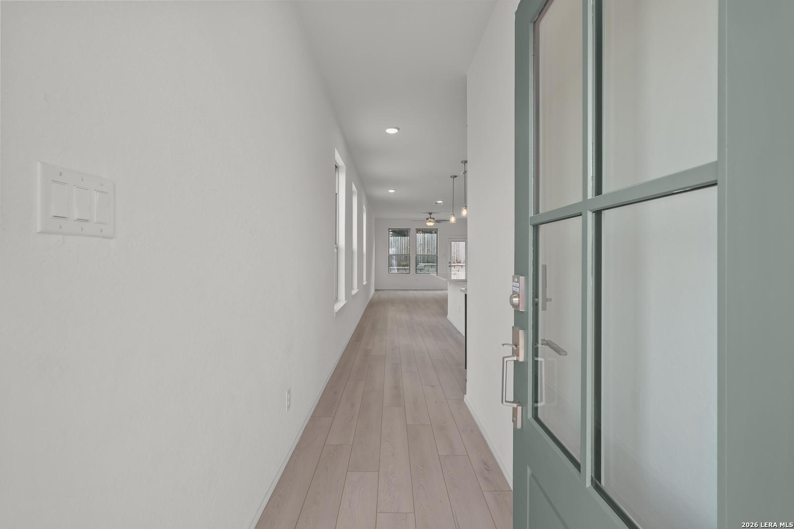 Bright entryway and hallway leading to open floor plan in The Gillian C home at Meadows at Oak Creek, San Antonio, Texas.