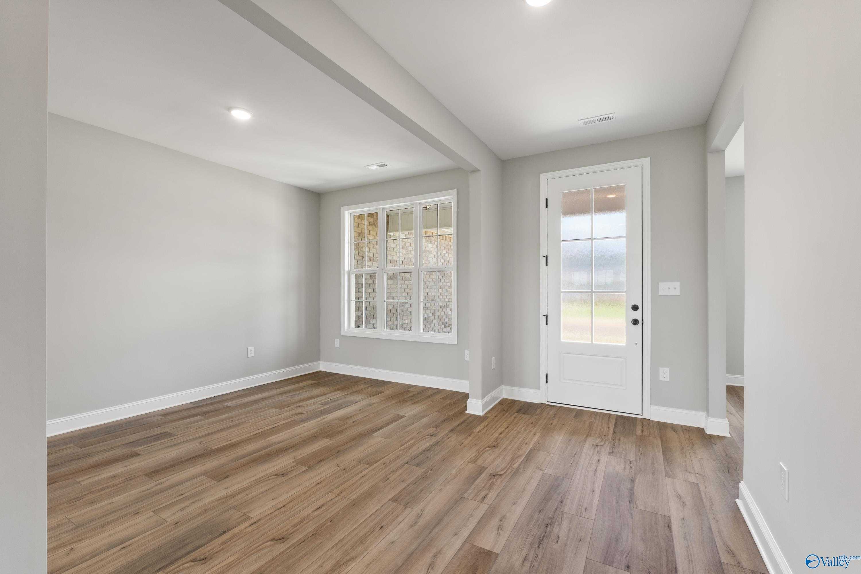 Bright entry foyer with hardwood floors, large window, and glass back door in Davidson Homes The Rockford B, Toney, Alabama