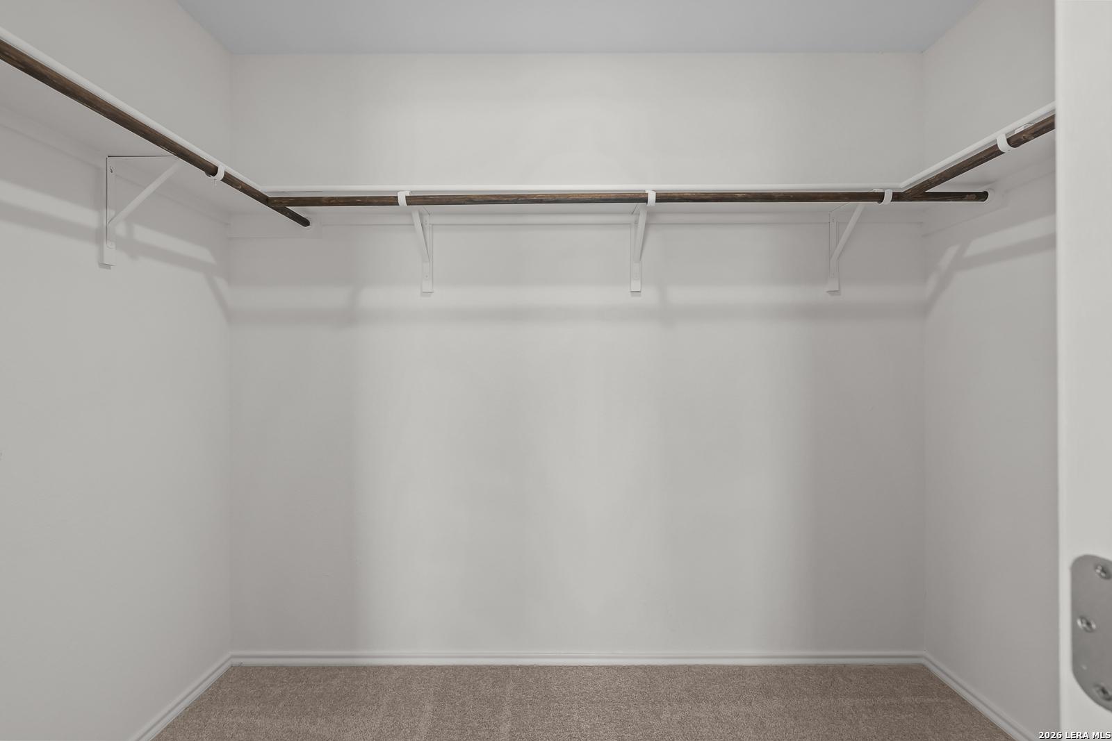Spacious walk-in closet with built-in shelving in The Gillian C floor plan at Meadows at Oak Creek, San Antonio, Texas.