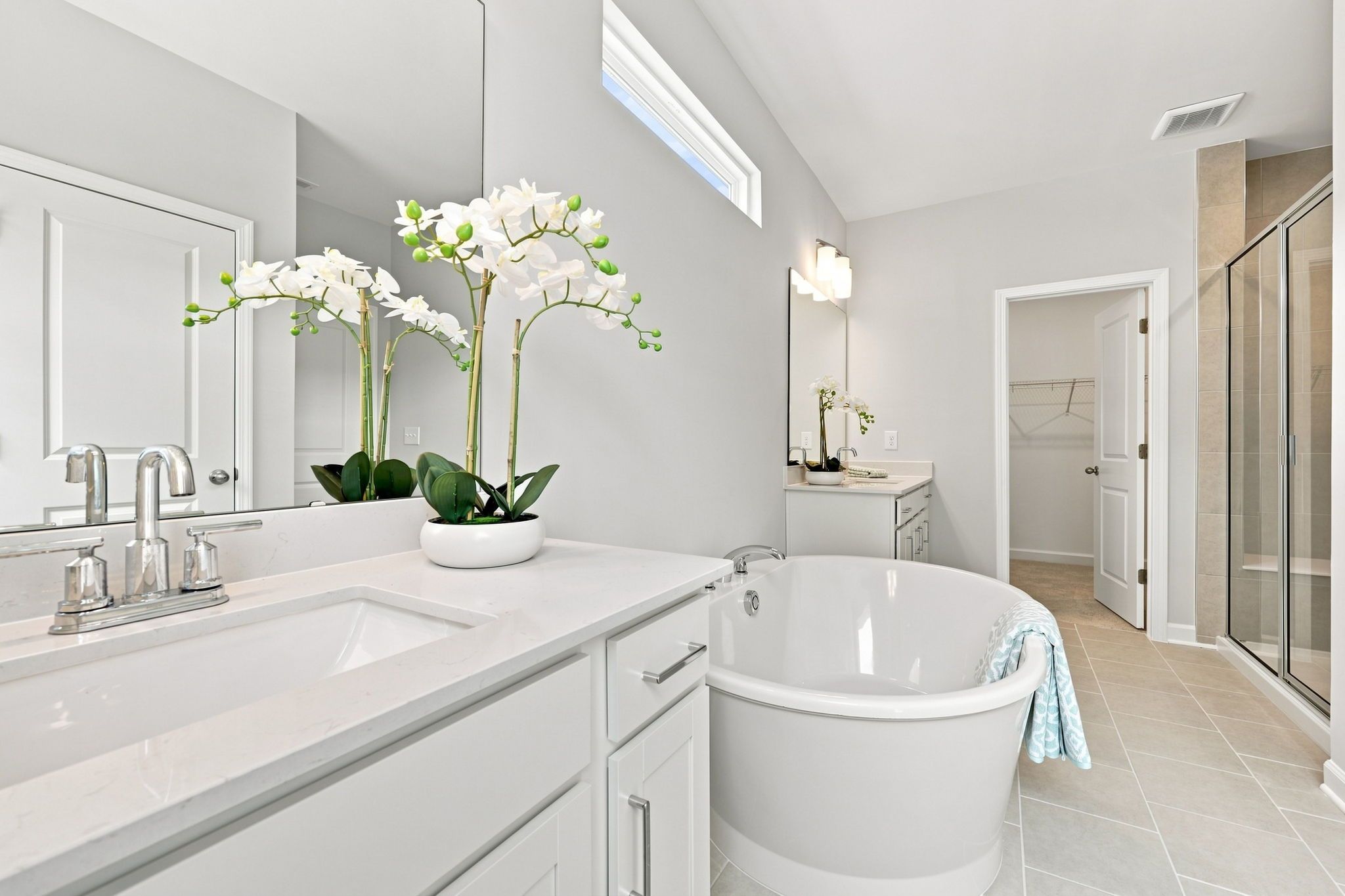Spacious master bathroom in The Jordan featuring a soaking tub, dual vanity, and walk-in closet in Knightdale, NC.