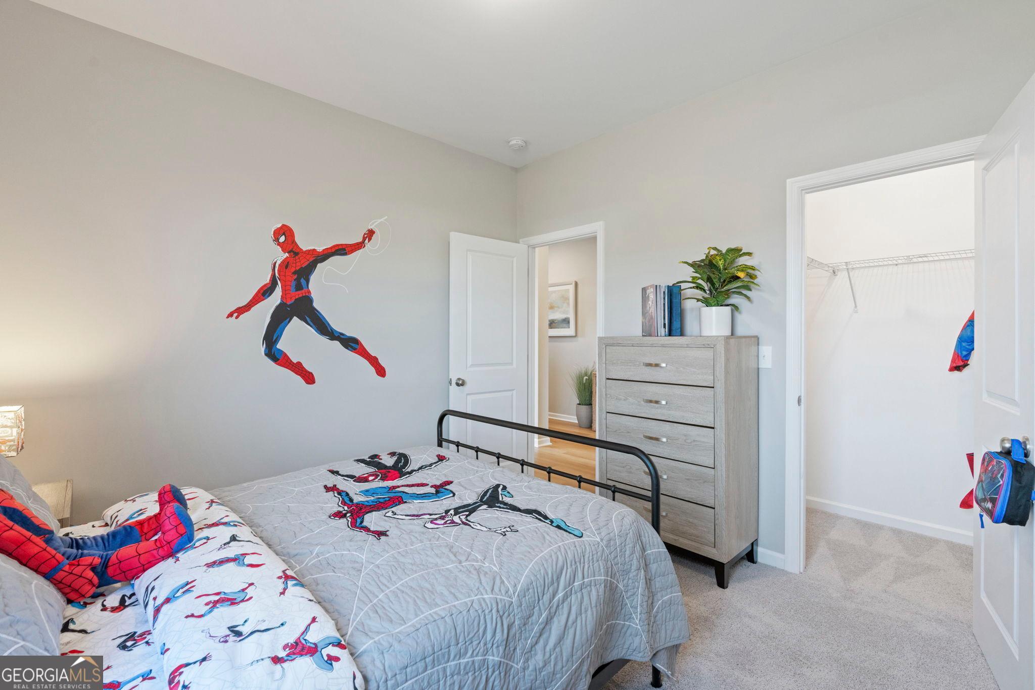 Spider-Man themed child's bedroom with twin bed, dresser, and open closet in Evermore Homes The Phoenix, Ivy Glen, Perry, Georgia