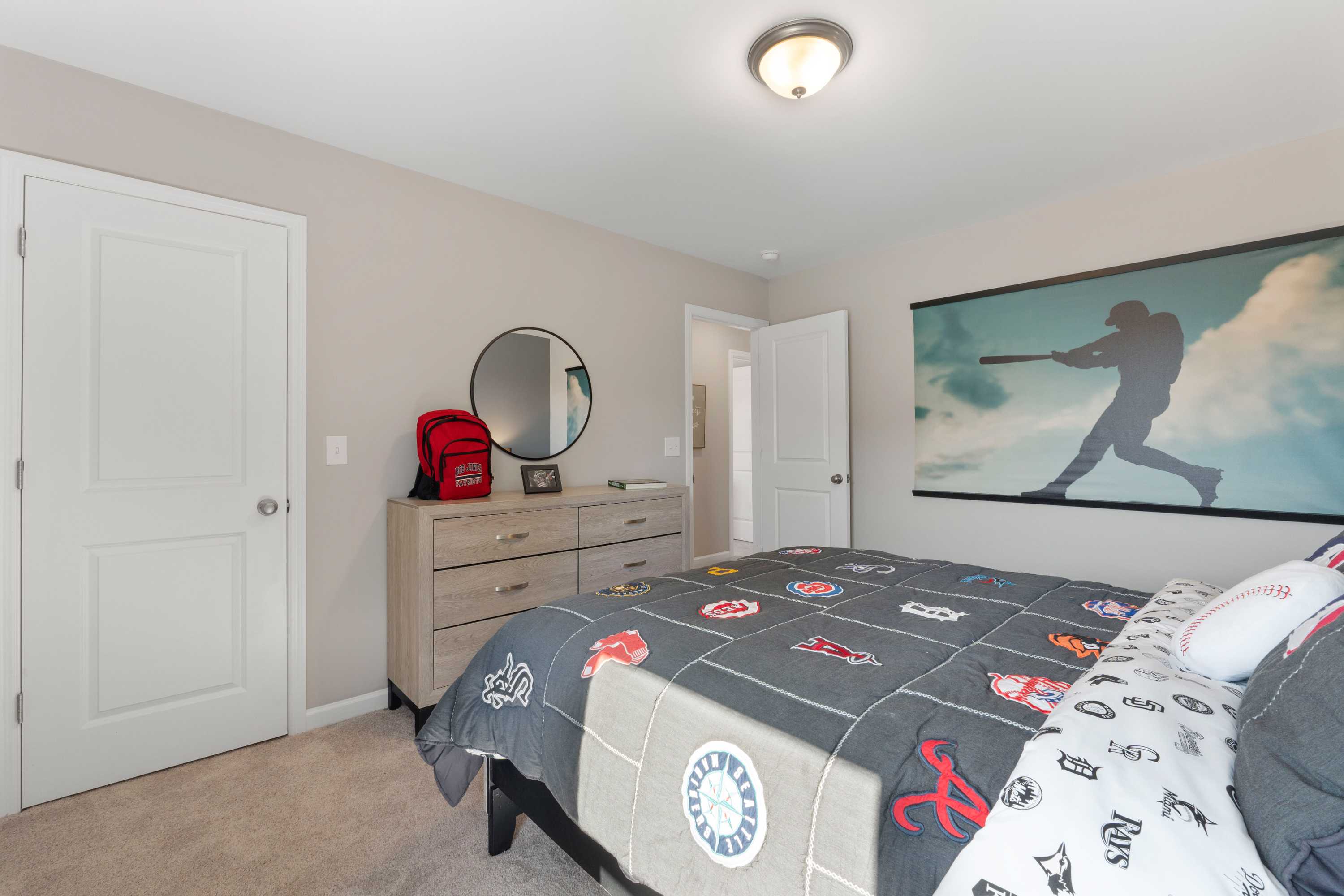 Baseball-themed boy's bedroom at Evergreen Mill in Madison, Alabama featuring twin bed, sports comforter and wall mural