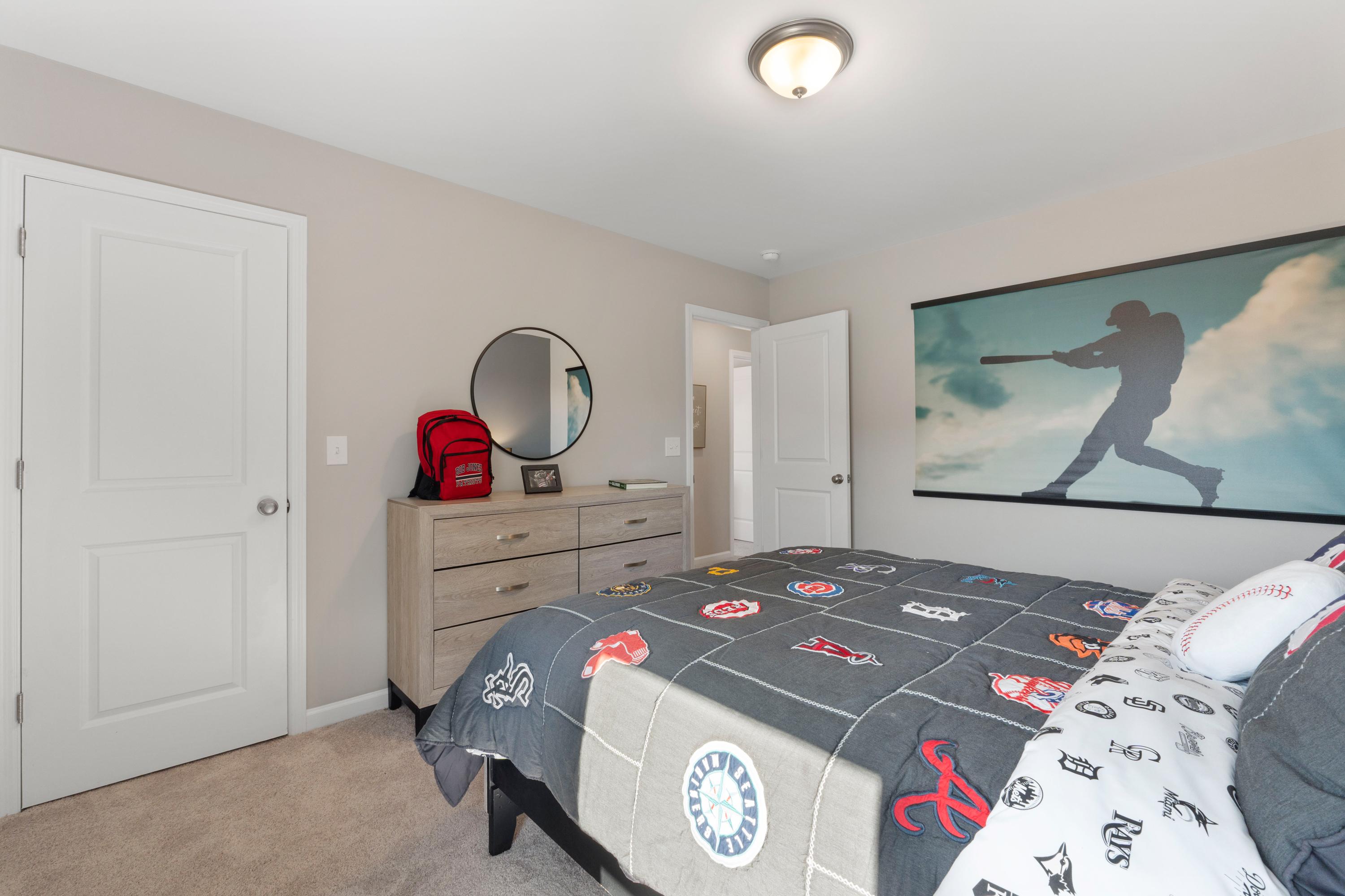 Baseball-themed boy's bedroom at Evergreen Mill in Madison, Alabama featuring twin bed, sports comforter and wall mural