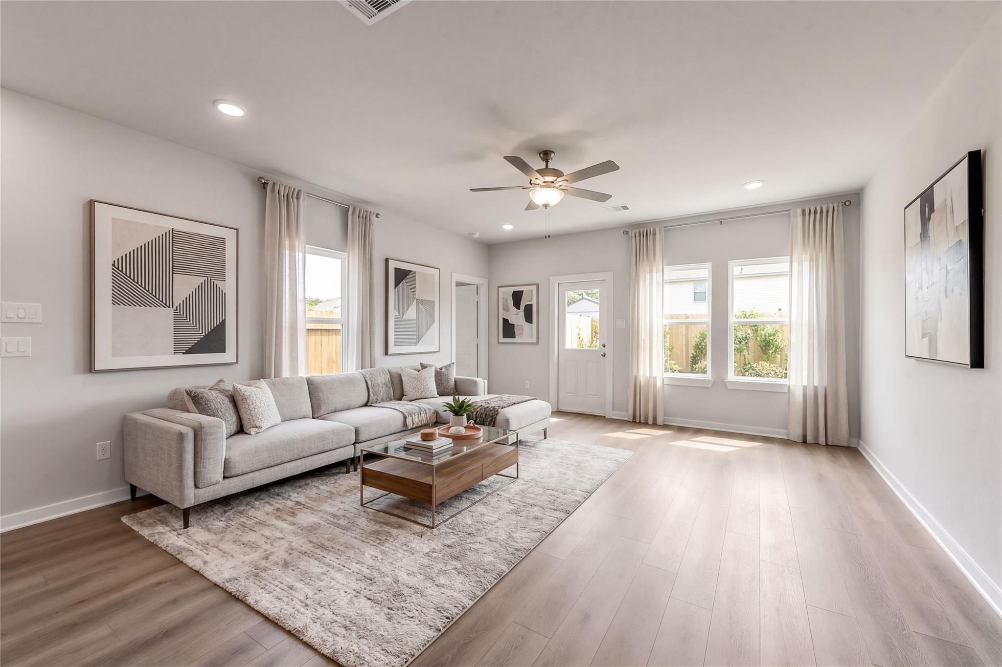 Bright, open-concept living room with modern decor in The Brazos E floor plan at The Villages at WestPointe, Dayton, TX.
