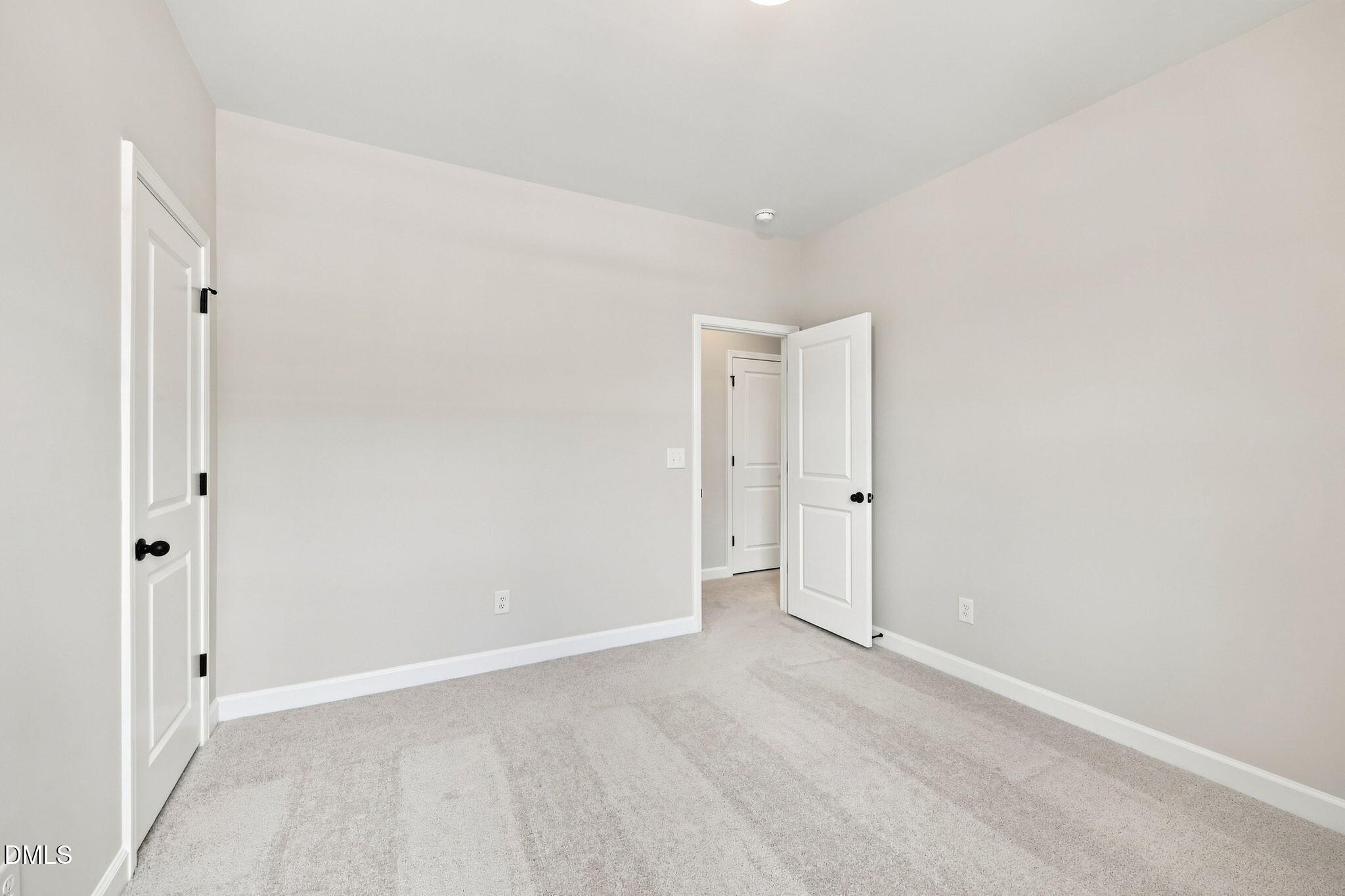 Neutral bedroom with plush carpet and white doors in The Harris C floor plan at Forestville Yard in Knightdale, NC.