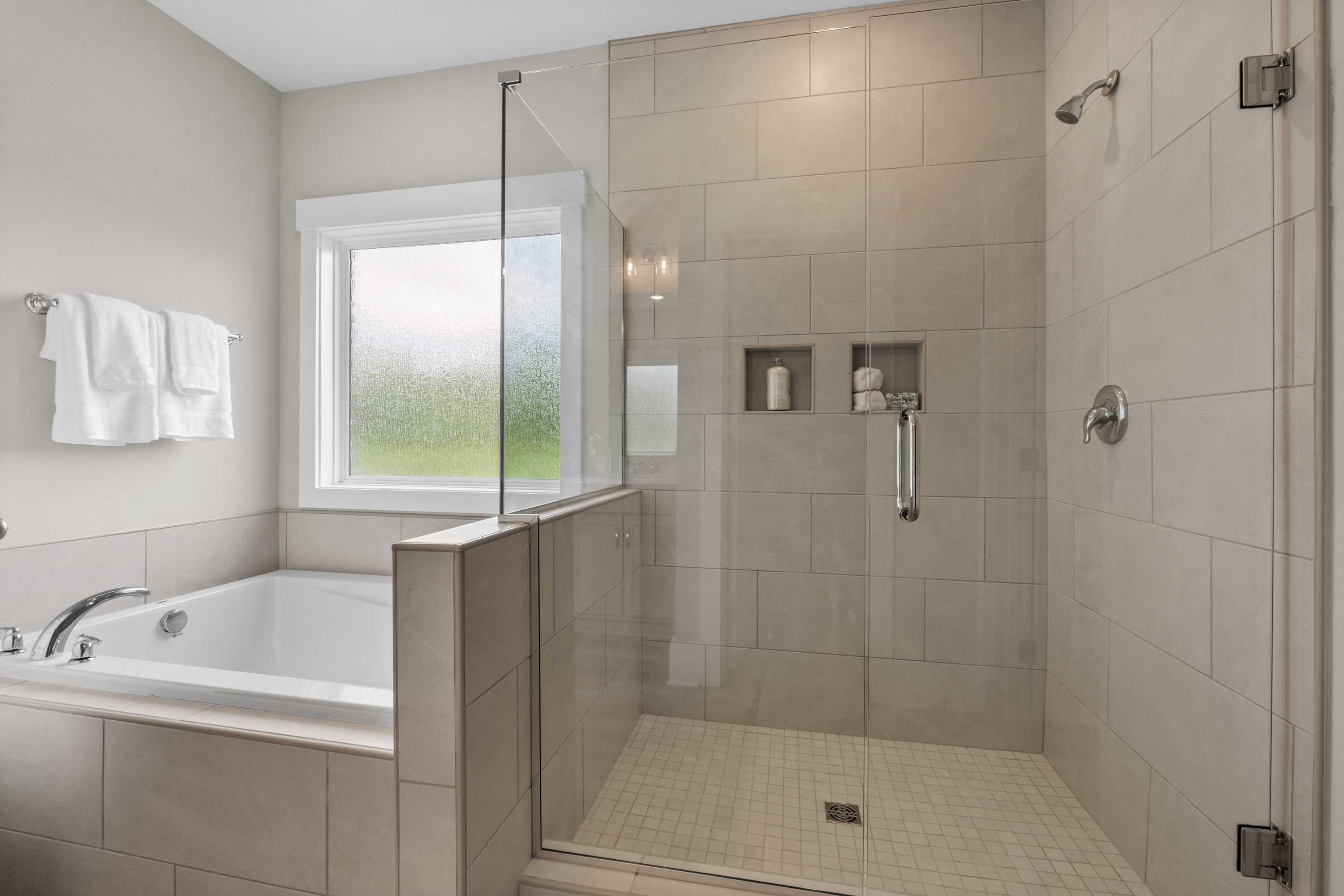 Spacious master bathroom at The Highlands in Arab Alabama with freestanding tub and glass shower enclosure