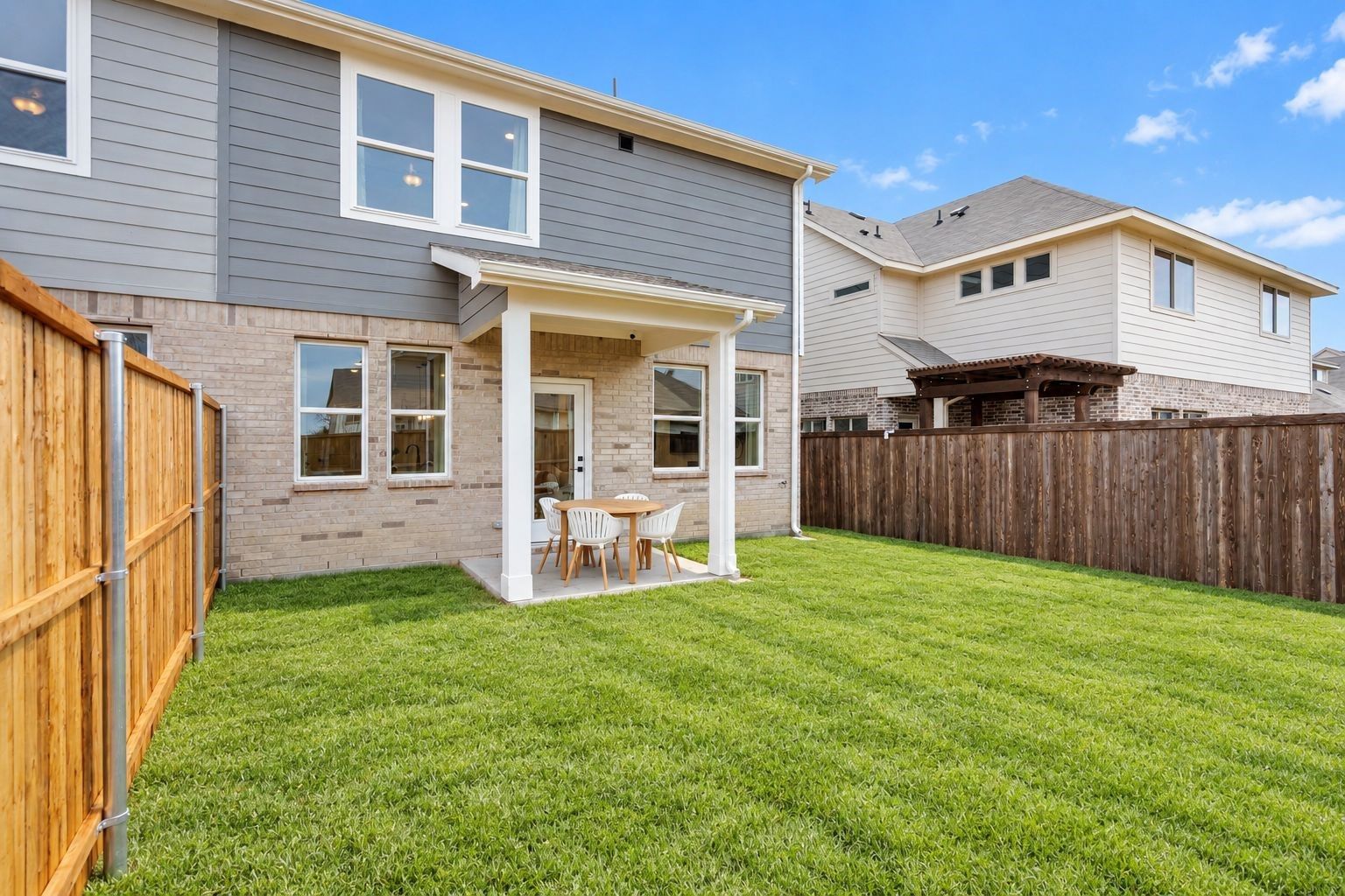 Covered patio with dining set overlooking fenced backyard at Davidson Homes The Wake C, Lake Park Villas, Wylie, Texas