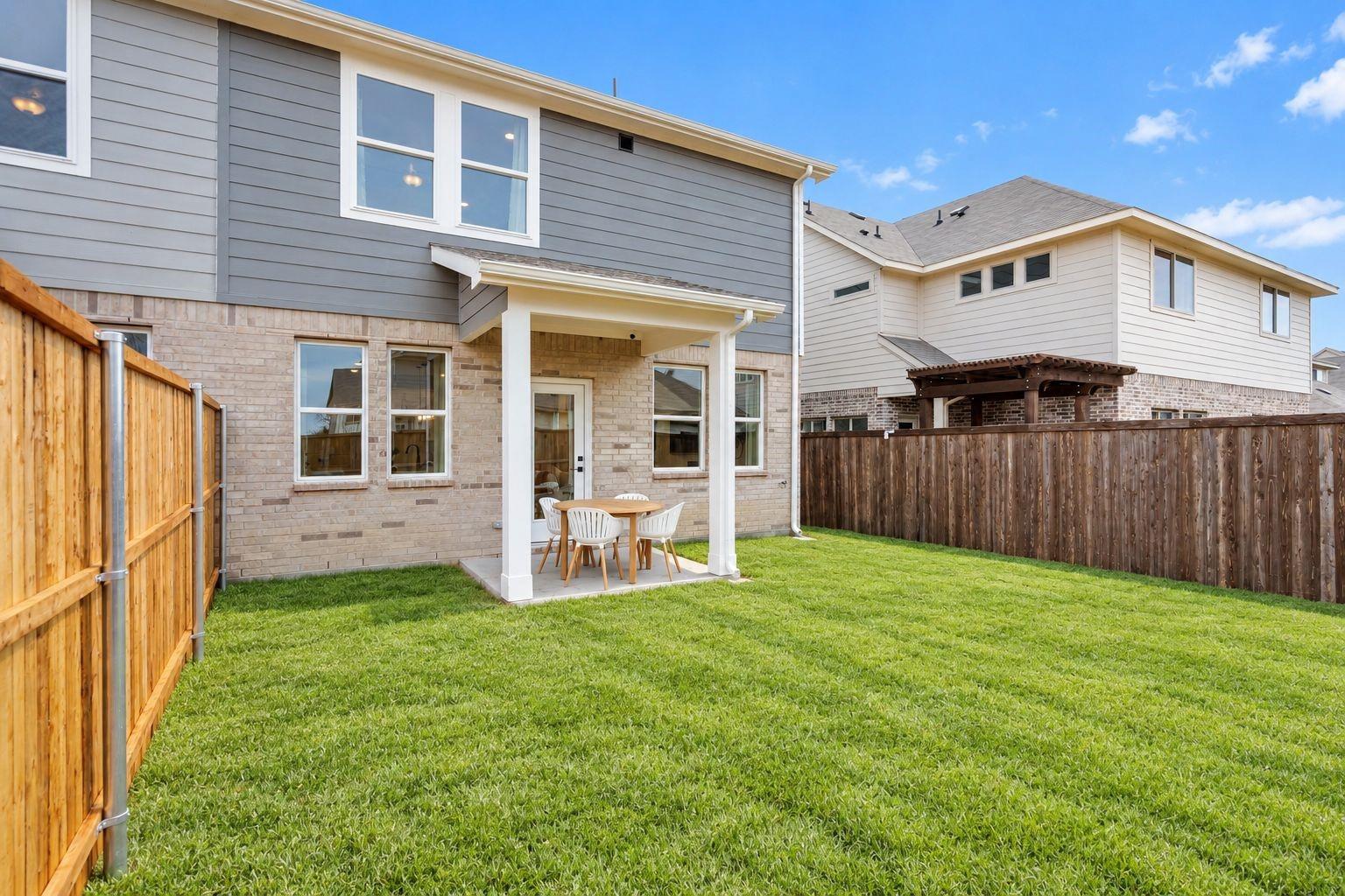 Covered patio with dining set overlooking fenced backyard at Davidson Homes The Wake C, Lake Park Villas, Wylie, Texas