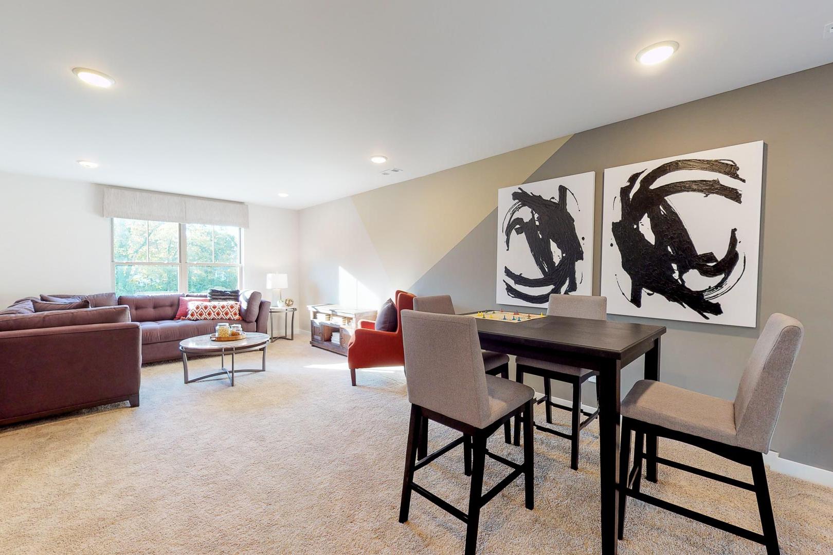 Spacious open-concept living room in Liberty Creek, Gallatin TN with leather sectional sofa, casual dining table, and abstract wall art