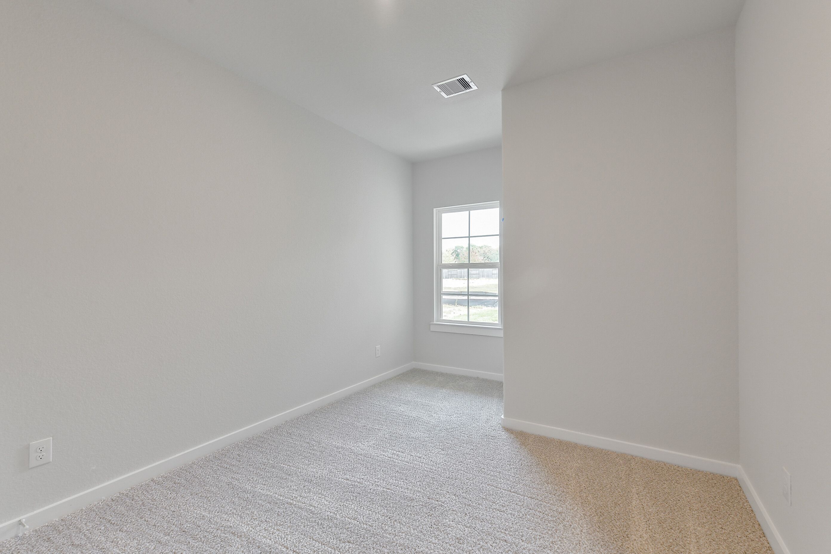 Bright secondary bedroom with gray carpet, light walls, and large window in Davidson Homes The Colorado G, Magnolia, Texas