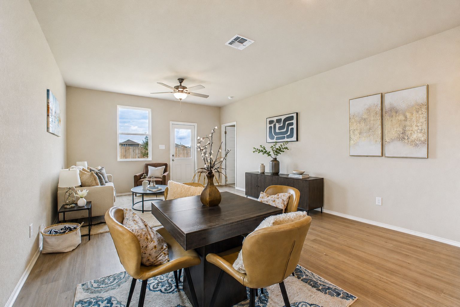 Open-concept dining and living area in The Comal by Davidson Homes featuring modern furniture and wood-style flooring.