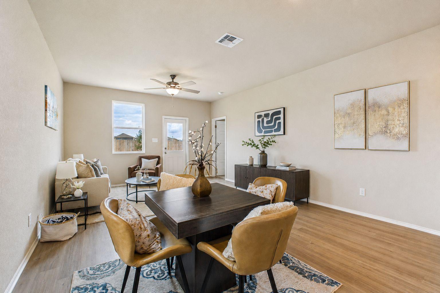 Open-concept dining and living area in The Comal by Davidson Homes featuring modern furniture and wood-style flooring.