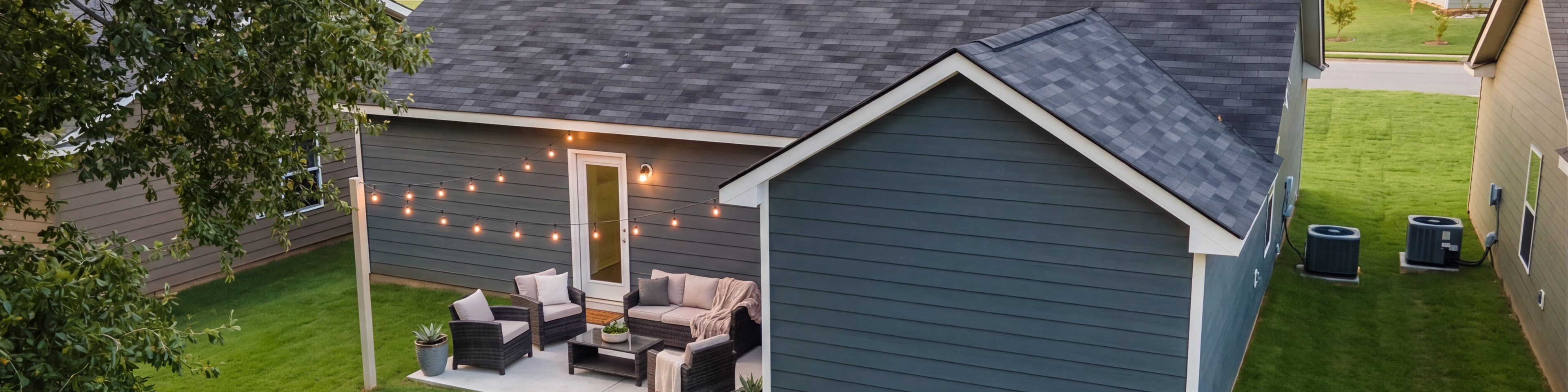 Spacious open-concept living room and kitchen at Summer Vineyard in Phenix City AL with white sofas, island bar, and stainless appliances