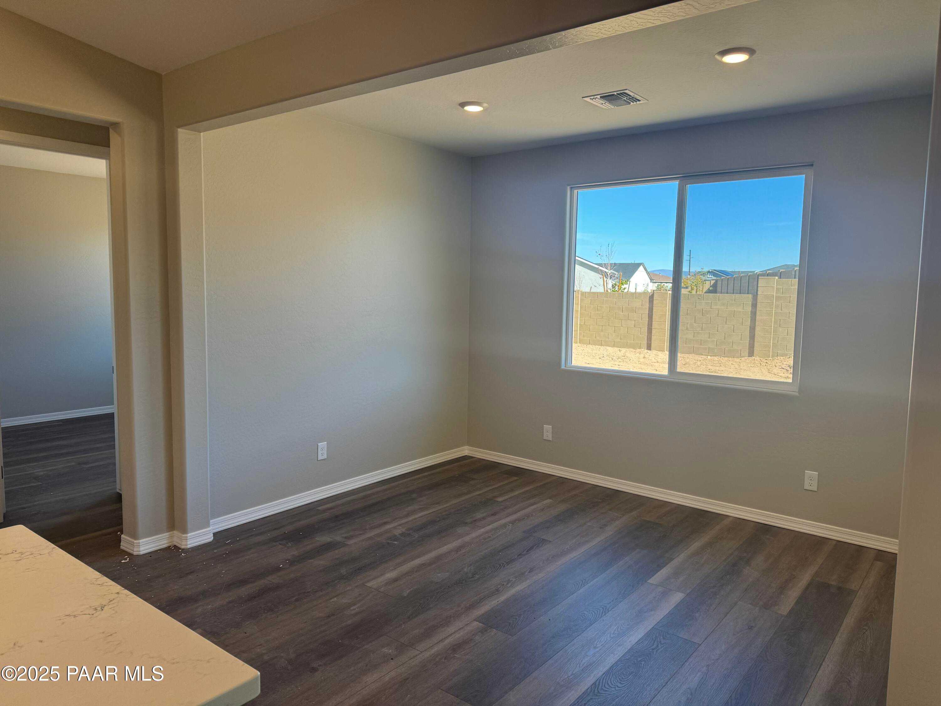 Bright flex room with large window overlooking desert view, beige walls, wood flooring in Davidson Homes The Monarch E, Prescott AZ