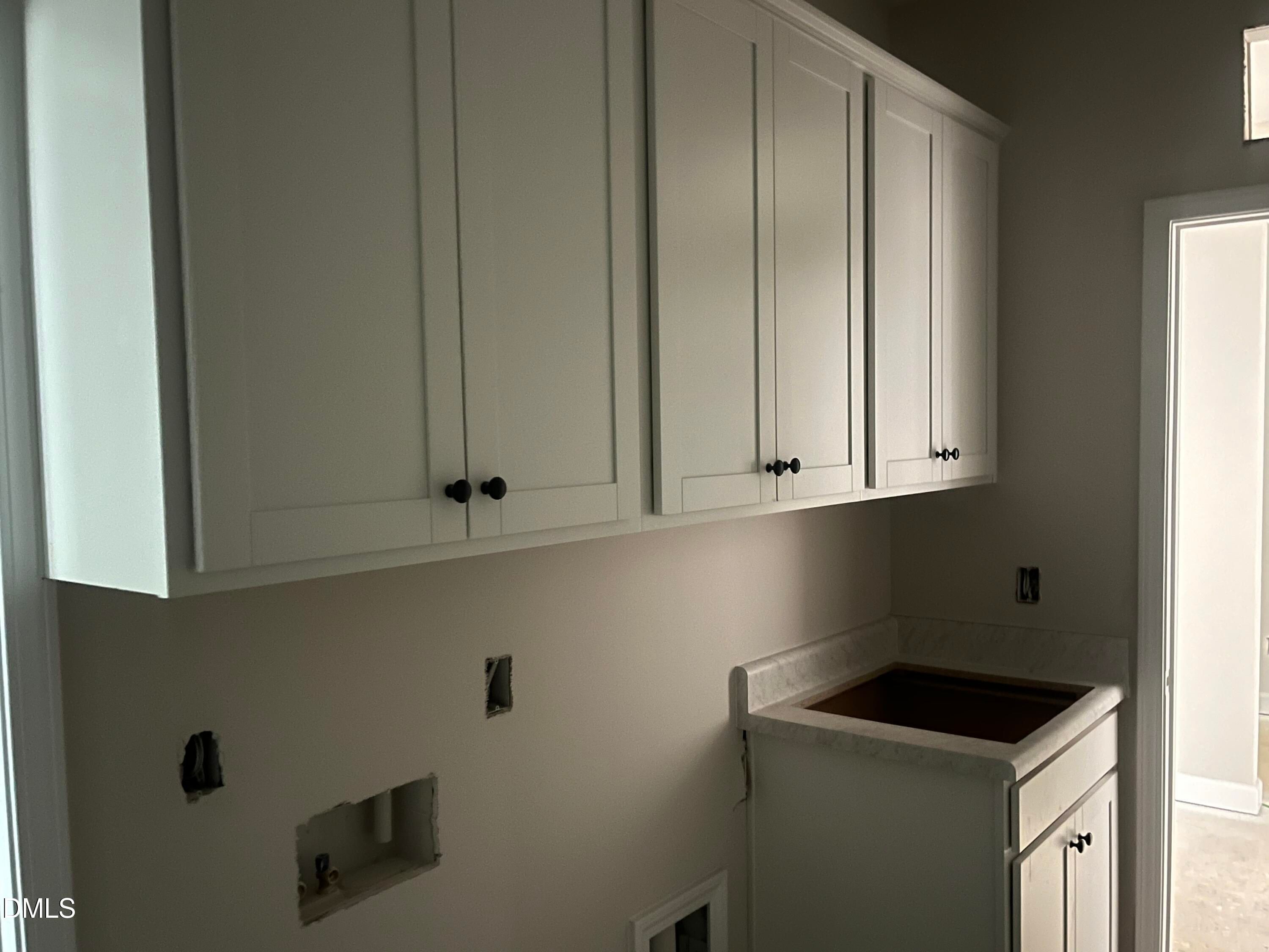 White shaker cabinets and utility sink in laundry room of Davidson Homes Ashport L in Wake Forest, NC