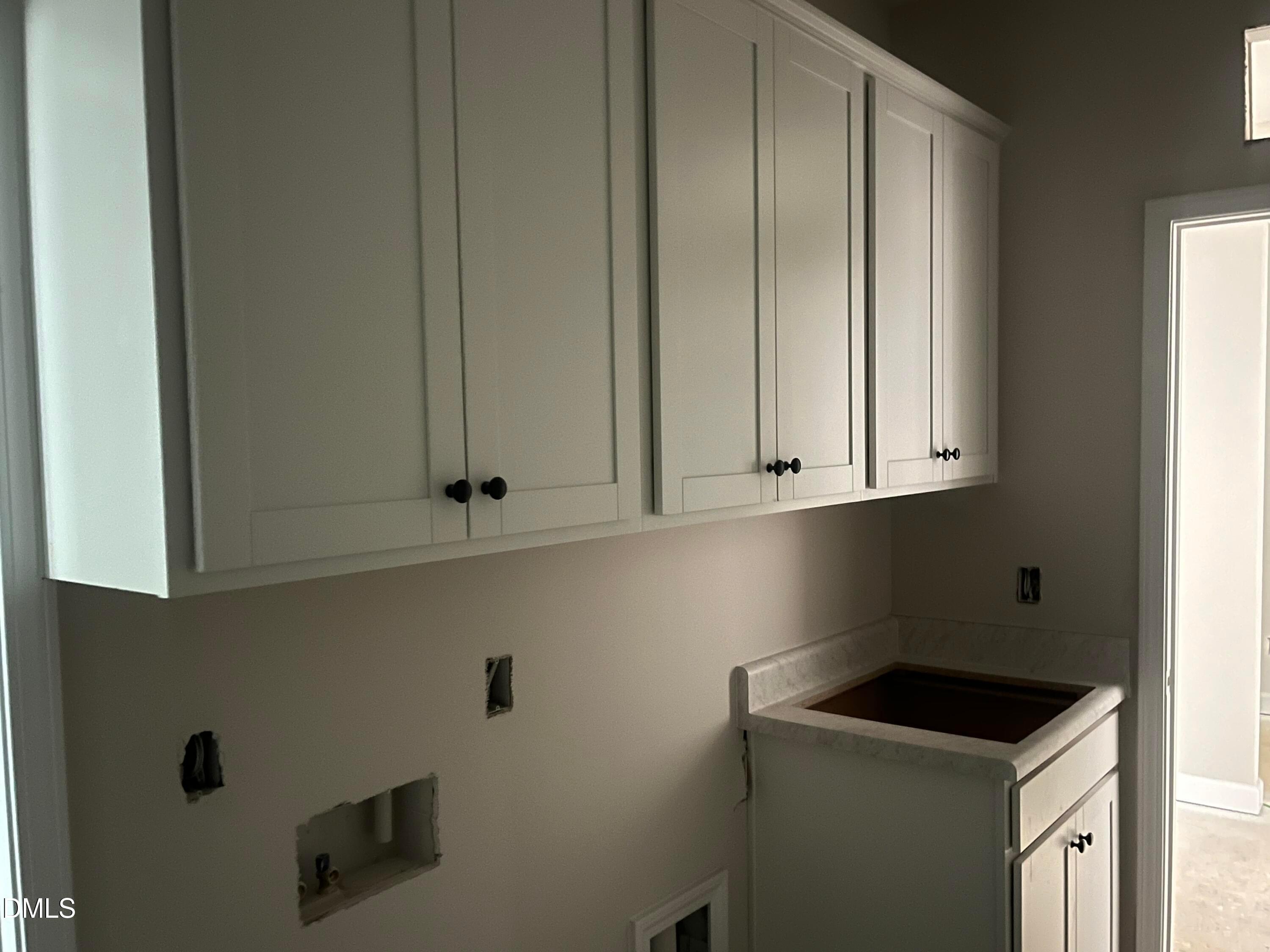 White shaker cabinets and utility sink in laundry room of Davidson Homes Ashport L in Wake Forest, NC